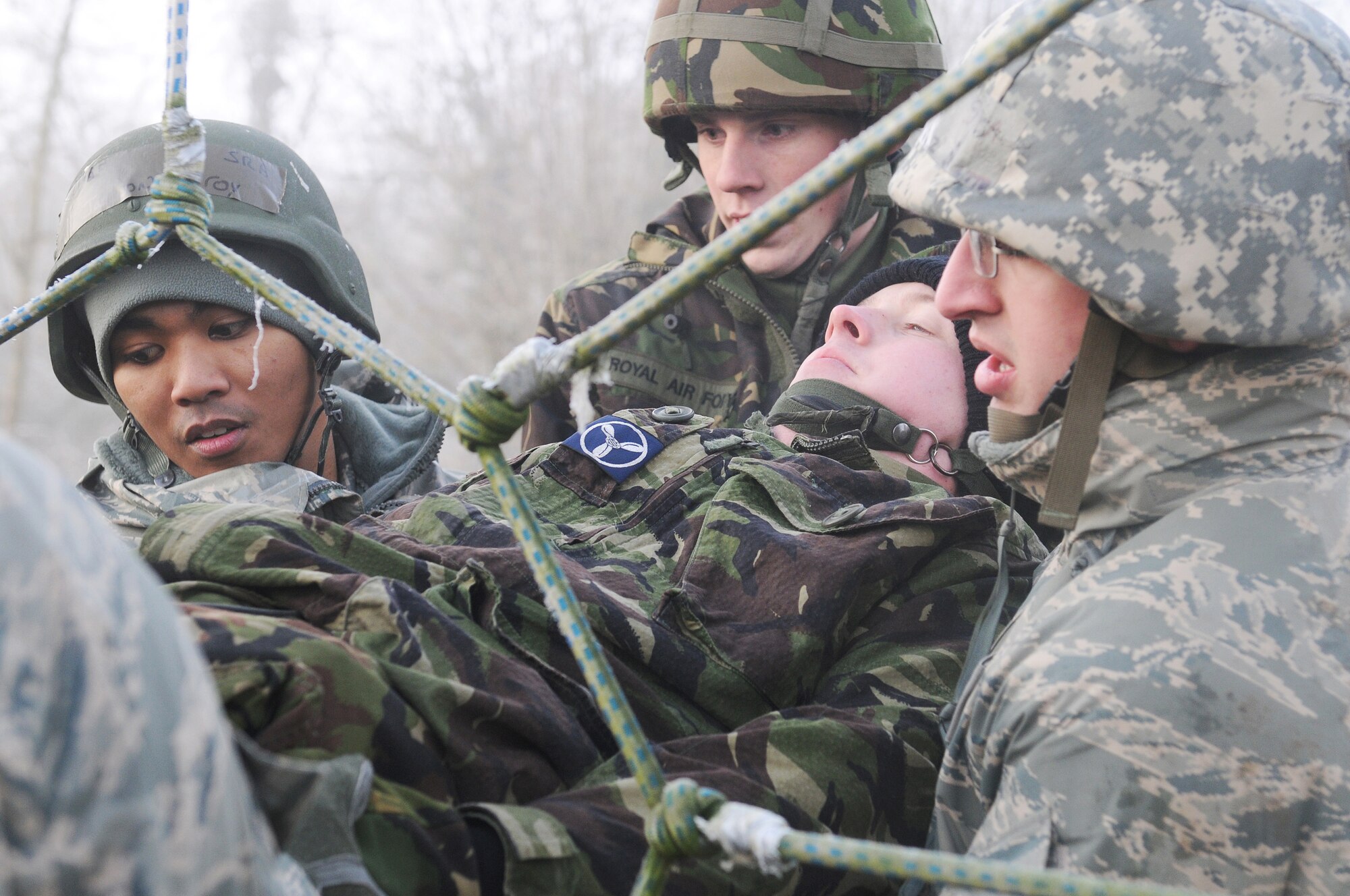 RAF MARHAM, England -- Airmen from RAFs Mildenhall and Marham band together to overcome an obstacle at the low-ropes course during Leader, Ethos and Air Power Training Day here Dec. 6, 2010. This activity required leadership and mental and physical strength of participants to get all team members to the finishing point. (U.S. Air Force photo/Senior Airman Tabitha M. Lee)