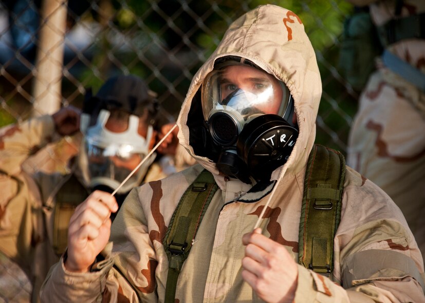 An Airman pulls the cords tight on the hood of his chemical suit top in an Alarm Black condition during the chemical, biological, radiological, nuclear and explosive training course at Eglin Air Force Base, Fla.  The eight-hour course combines computer based and hands-on training on how and when to wear the gear, UXOs and protective measures.  The 96th Civil Engineer Squadron’s emergency readiness flight teaches the hands-on course up to 75 times a year.  (U.S. Air Force photo/ Samuel King Jr.)