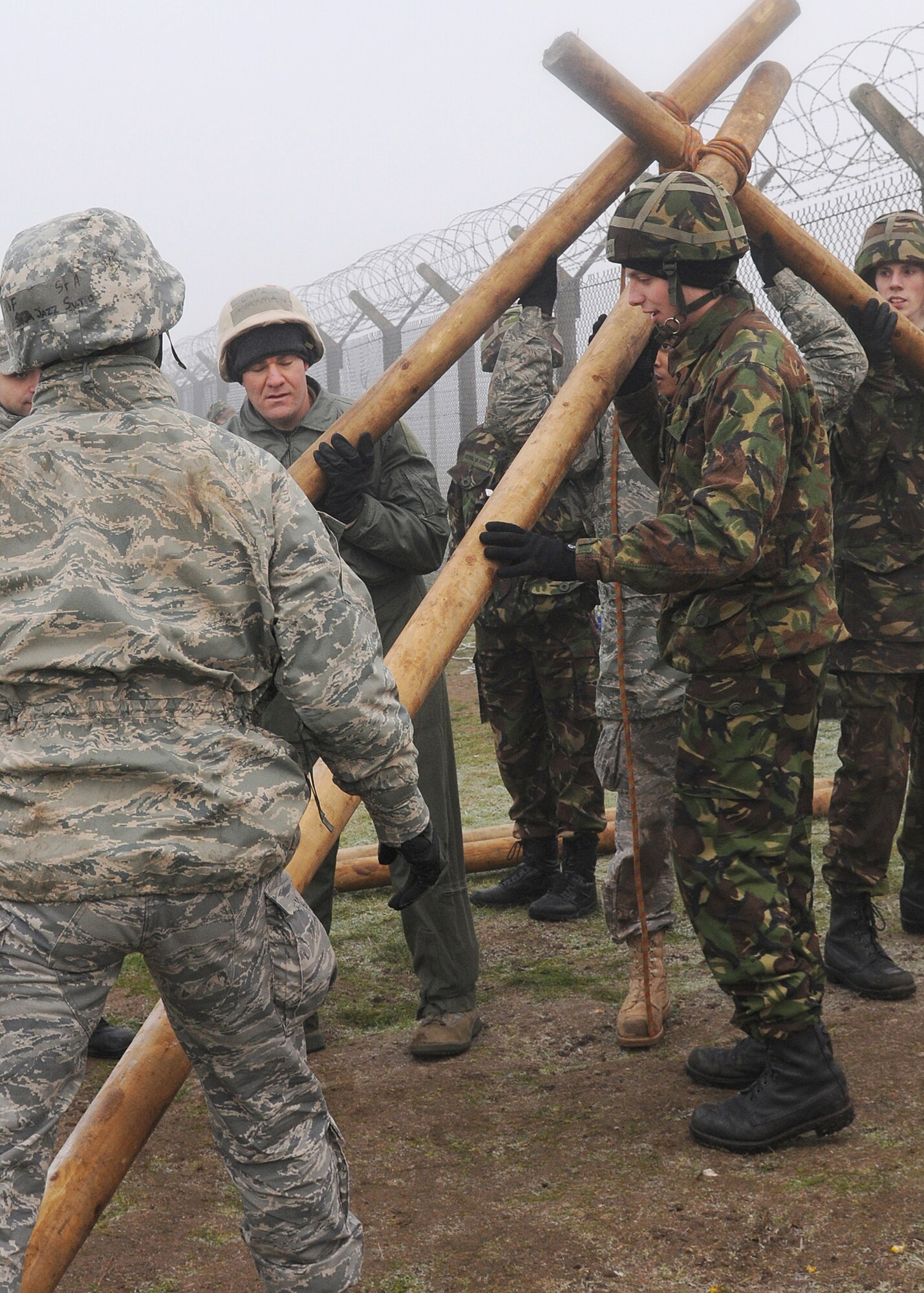 RAF MARHAM, England -- Airmen from RAFs Mildenhall and Marham work together to build a sling shot to launch a ball at a target during Leader, Ethos and Air Power Training Day here Dec. 6, 2010. Teams were given raw materials to build a device to launch a volleyball with distance and accuracy. (U.S. Air Force photo/Senior Airman Tabitha M. Lee) 
