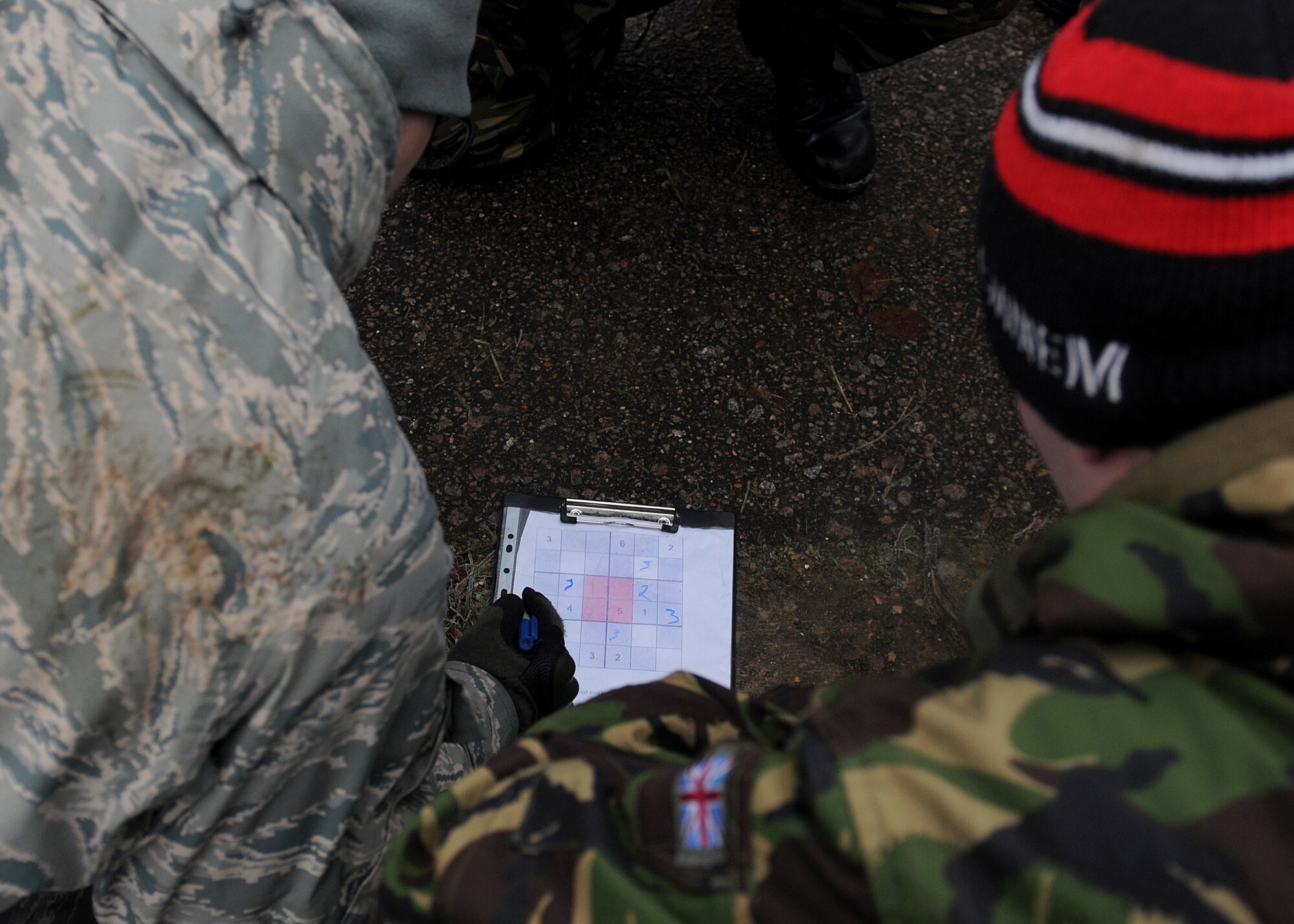 RAF MARHAM, England -- Airmen from RAFs Mildenhall and Marham work together to solve a Sudoku puzzle during a team building exercise on Leader, Ethos and Air Power Training Day here Dec. 6, 2010. Participants were broken into 16 teams that performed various tasks competing against each other for points. (U.S. Air Force photo/Senior Airman Tabitha M. Lee)  