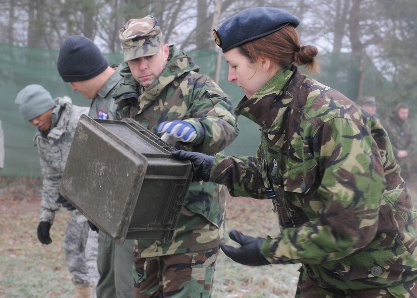 RAF MARHAM, England -- Tech. Sgt. Travis Romesha, 100th Air Refueling Wing Inspections and Readiness, hands RAF Flt. Lt. Sophia Darby, 31st Squadron, RAF Marham, a plastic box as part of a team building exercise during Leader, Ethos and Air Power Training Day here Dec. 6, 2010. Activities of the day included paintball, target practice, low-ropes challenge and a mind-over-matter exercise. (U.S. Air Force photo/Senior Airman Tabitha M. Lee) 