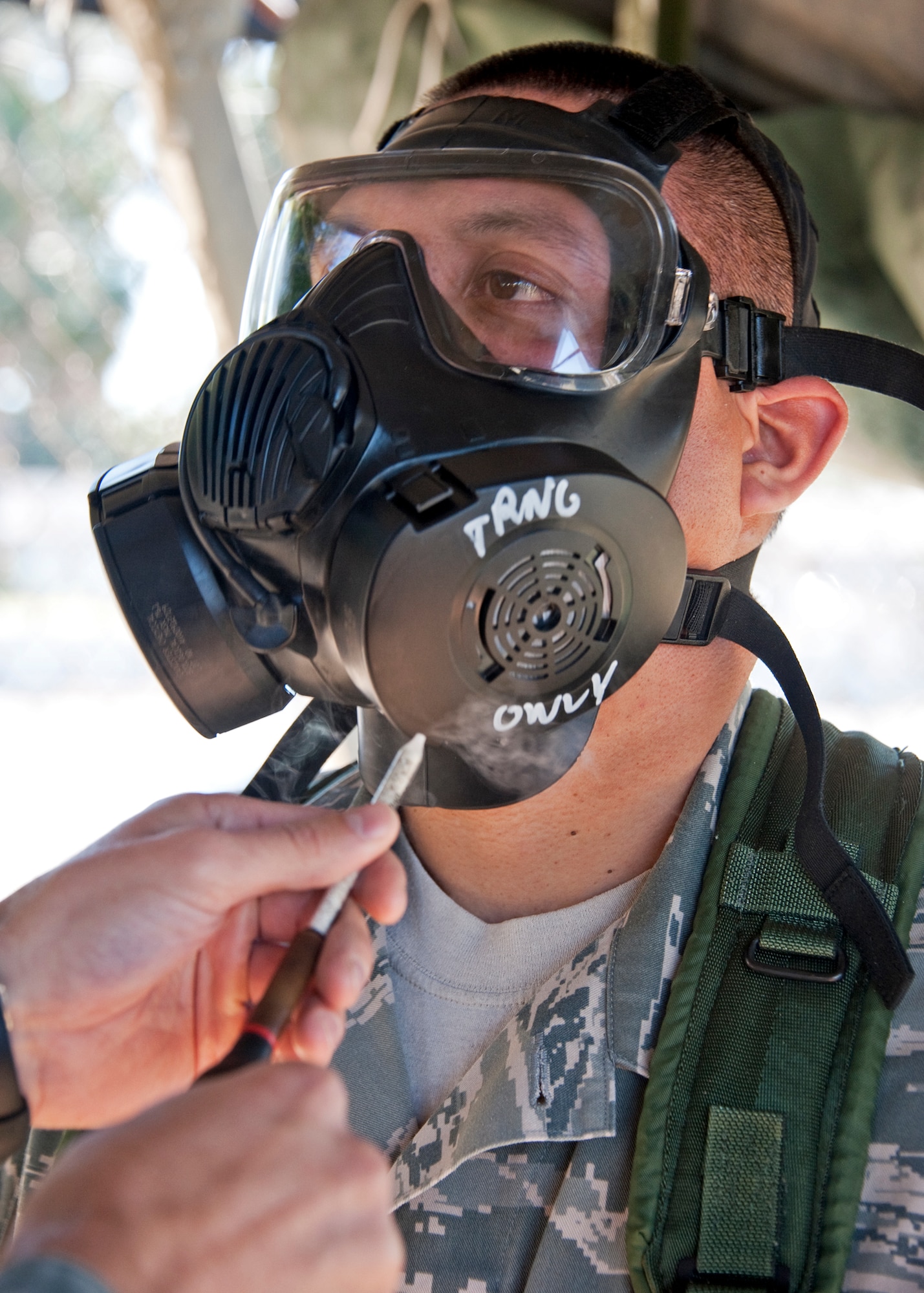 An Airman ensures the mask is sealed as a chemical irritant is placed in front of the filters of his M-50 gas mask during the chemical, biological, radiological, nuclear and explosive training course at Eglin Air Force Base, Fla.  The eight-hour course combines computer based and hands-on training on how and when to wear the gear, UXOs and protective measures.  The 96th Civil Engineer Squadron’s emergency readiness flight teaches the hands-on course up to 75 times a year.   (U.S. Air Force photo/ Samuel King)