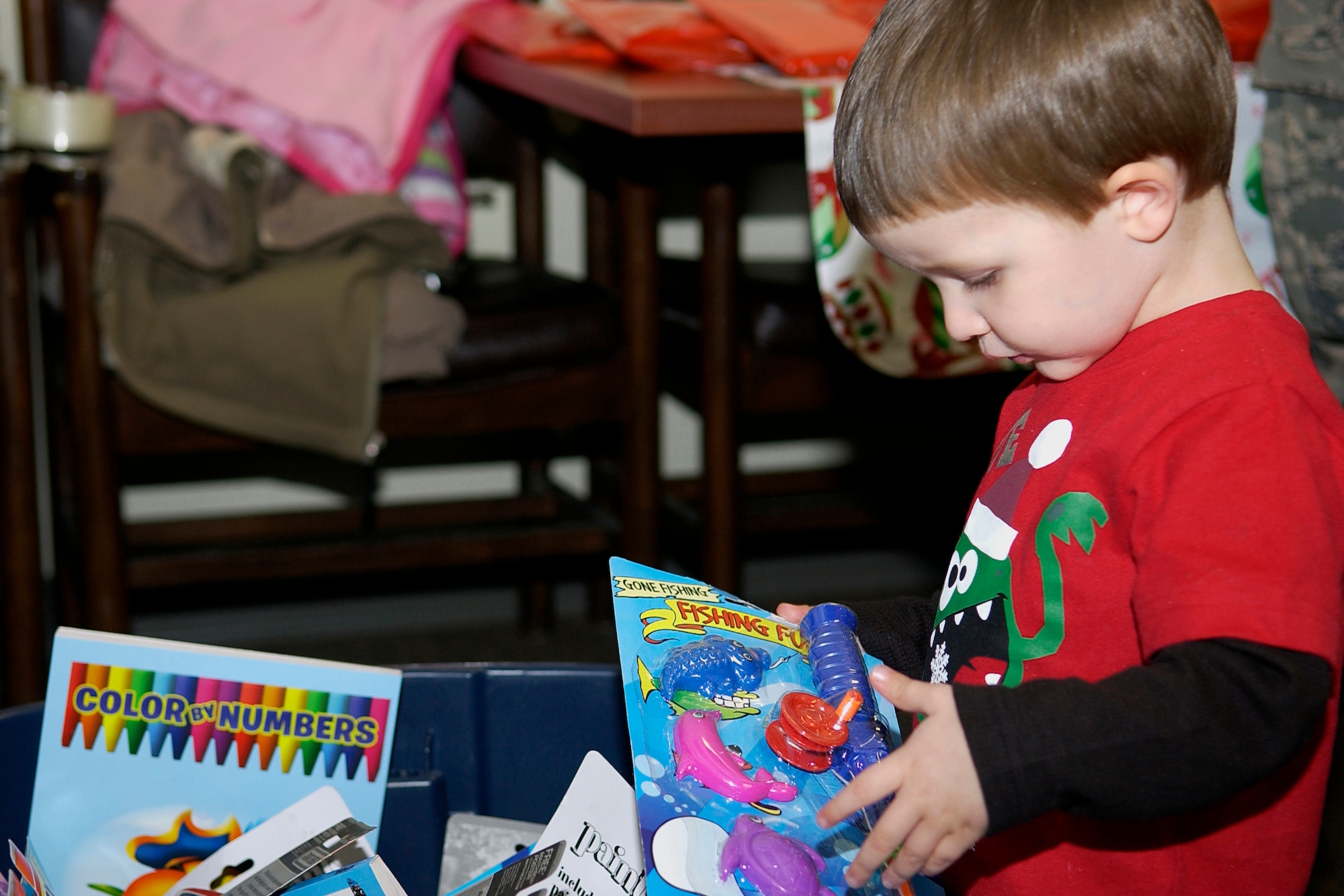 GRISSOM AIR RESERVE BASE, Ind. -- Cooper Prifogle, 2, contemplates picking a fishing toy set as his gift from Santa after meeting the jolly man in red just moments earlier Dec. 4. Santa visited with Cooper and other 434th Air Refueling Wing kids during a special party hosted by the Grissom Airman and Family Readiness office. Cooper is the grandson of Tech. Sgt. Jeff Baker, 434th Aircraft Maintenance Squadron crew chief. (U.S. Air Force photo/Senior Airman Damon Kasberg) 