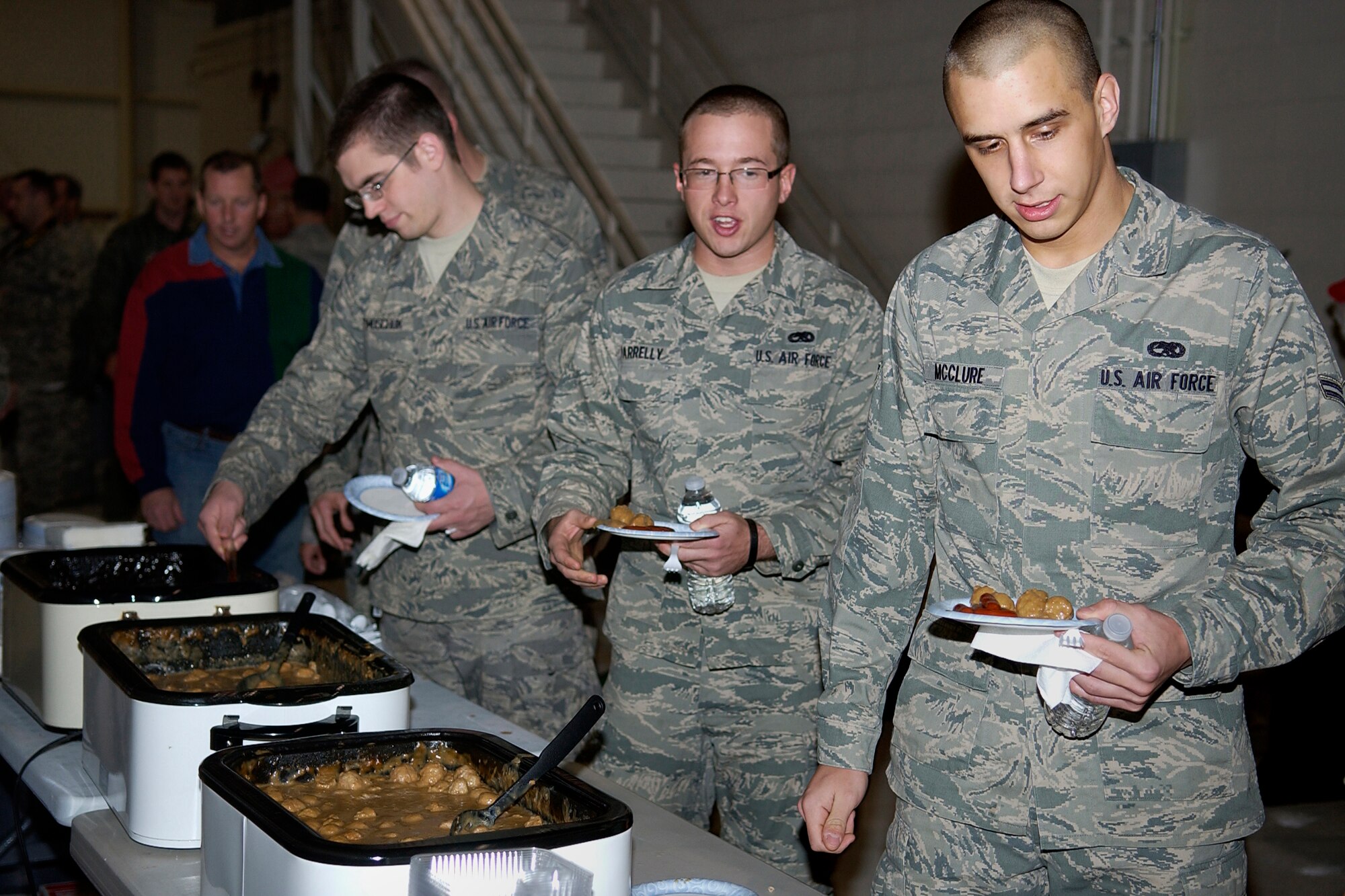 GRISSOM AIR RESERVE BASE, Ind. -- Senior Airman Phillip Timoschuck along with Airmen 1st Class Derek Parrelly and Anthony McClure, load up their plates during the 434th Aircraft Maintenance Squadron Christmas party held here during the December unit training assembly. Airmen Timoschuck and Parrelly are jet engine mechanics with the 434th AMXS. Airman McClure is an aerospace propulsion apprentice with the 434th Maintenance Squadron. (U.S. Air Force photo/Senior Airman Damon Kasberg) 
