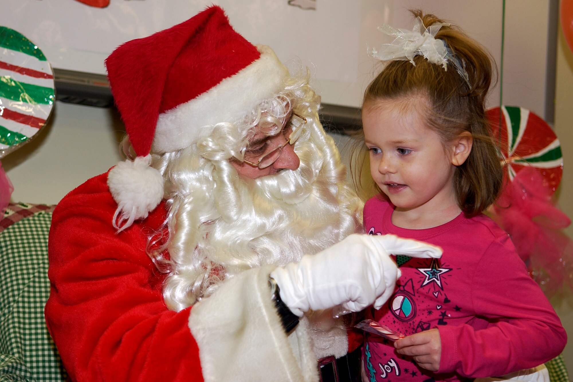 GRISSOM AIR RESERVE BASE, Ind. -- After getting a candy cane, Gretchen Prifogle, 4, talks with during a family Christmas party hosted by the Grissom Airman and Family office here Dec. 4. Gretchen is the granddaughter of Tech. Sgt. Jeff Baker, 434th Aircraft Maintenance Squadron crew chief. (U.S. Air Force photo/Senior Airman Damon Kasberg) 