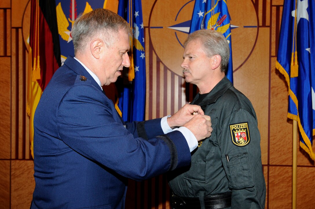 Gen. Roger Brady, U.S. Air Forces in Europe commander, presents a USAFE Medal of Distinction to Horst Mehlinger, a Germany security liaison who has worked closely with the command for nearly three decades, during a ceremony at Ramstein Air Base, Germany, Dec. 8, 2010. The medal is awarded to non-U.S. citizens in recognition of extraordinary service, achievements, or support to the accomplishment of the mission of USAFE. (U.S. Air Force photo by Airman Kendra Alba) 