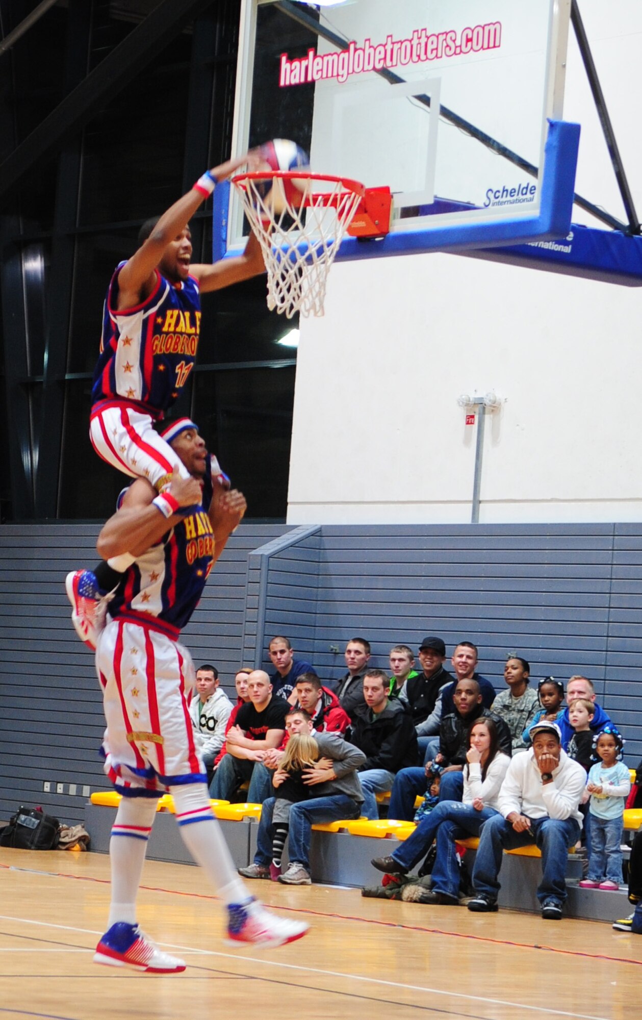Hammer Harrison, Harlem Globetrotters member, gives his teammate Cheese Chisholm a lift during a Military Holiday tour, Ramstein Air Base, Germany, Dec. 8, 2010. This tour was made possible by Navy Entertainment and Armed Forces Entertainment; this year's tour will feature 11 games on U.S. military bases in five countries: Germany, Italy, Greece, the Netherlands and the United Kingdom.  The Globetrotters are celebrating their 85th year entertaining audiences around the world. (U.S. Air Force photo by Senior Airman Brittany Nicole Perry)