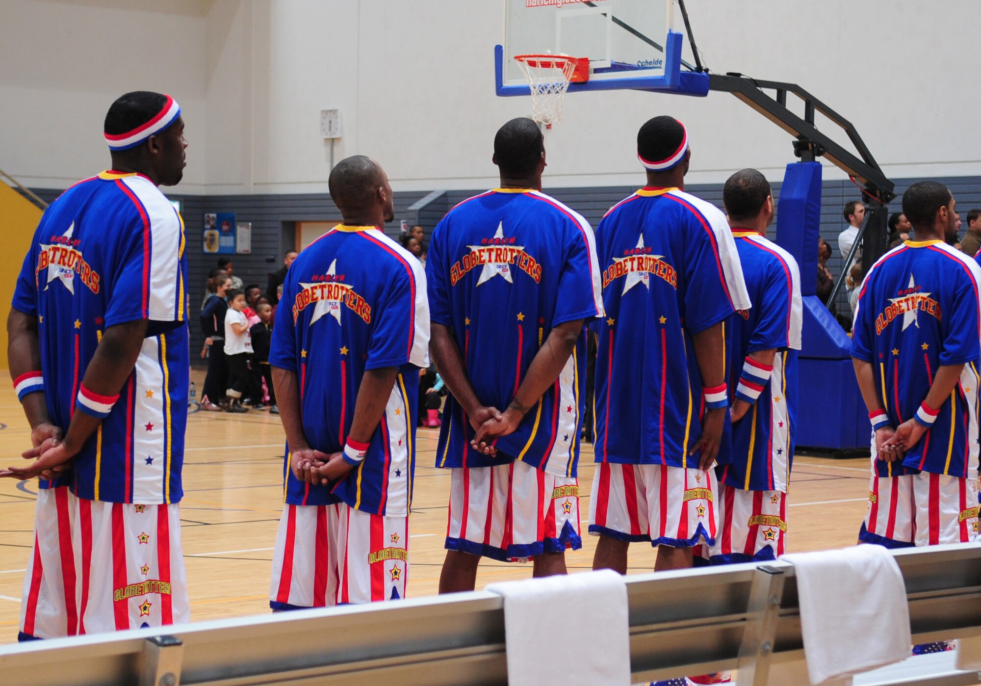 The Harlem Globetrotters pause for the National Anthem before performing for military members and their families during their ninth Military Holiday tour, Ramstein Air Base, Germany, Dec. 8, 2010. This tour was made possible by Navy Entertainment and Armed Forces Entertainment; this year's tour will feature 11 games on U.S. military bases in five countries: Germany, Italy, Greece, the Netherlands and the United Kingdom.  The Globetrotters are celebrating their 85th year entertaining audiences around the world. (U.S. Air Force photo by Senior Airman Brittany Nicole Perry)