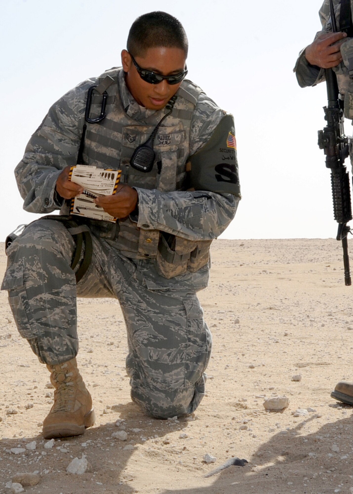 SOUTHWEST ASIA - Staff Sgt. Marcelino Ruiz, a 386th Expeditionary Security Forces Squadron patrolman, compares a suspicious item pointed out by a local national with pictures of unexploded ordnance in his Airman's Manual during patrols outside the perimeter of an undisclosed air base Nov. 29, 2010. Sergeant Ruiz is a member of the 386th ESFS Viper Team, which patrols more than 180 square kilometers of desert terrain to defending the base populace, including more than 2,000 Airmen, millions of dollars worth of equipment and numerous aircraft that support flying missions throughout U.S. Central Command. (U.S. Air Force photo by Senior Airman Laura Turner)