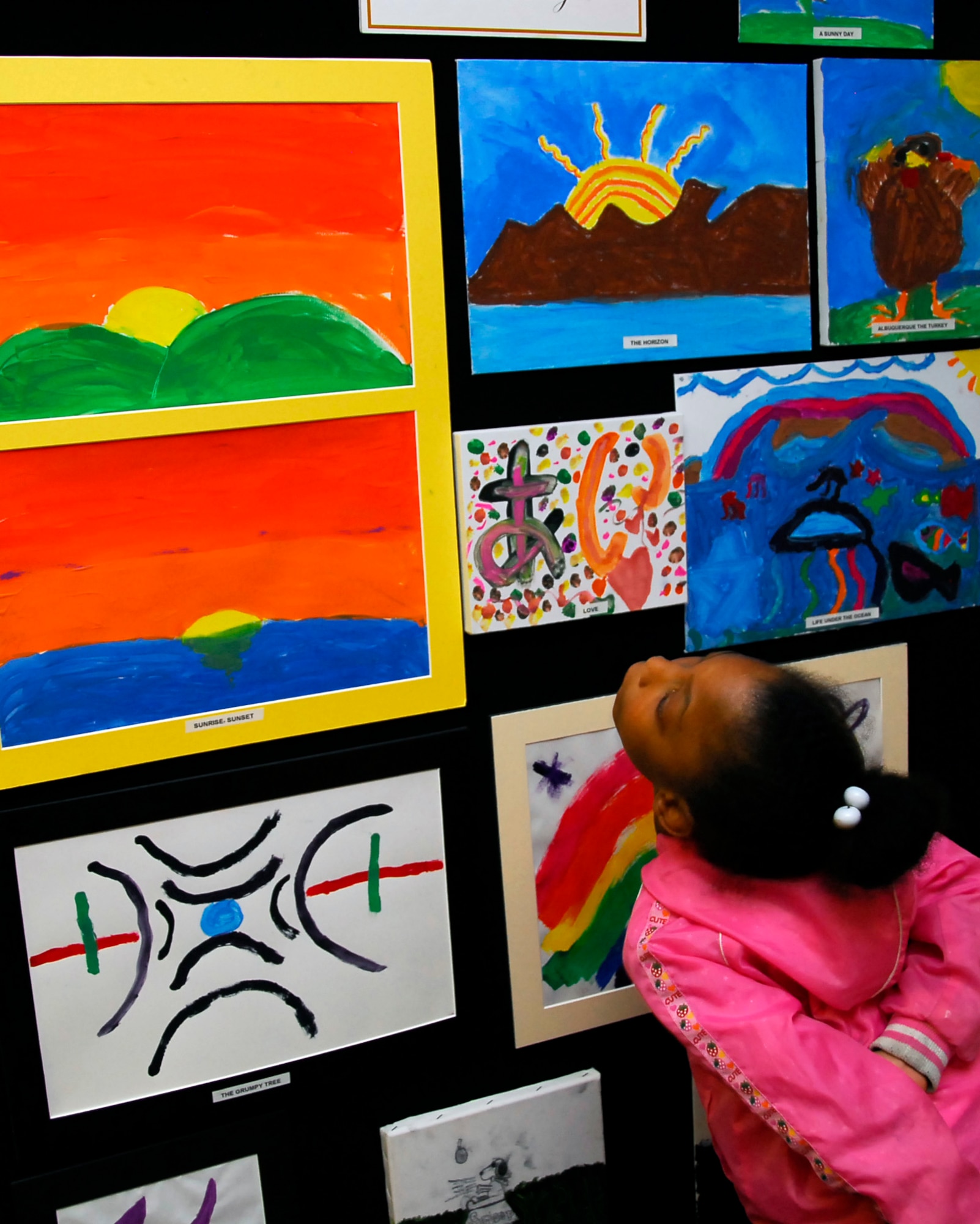 Ariya Turner, 6, daughter of Staff Sgt. Lynnette Mitchell, 320th Special Tactics Squadron, and participant in the Boys and Girls Club of America art exhibit looks at the other artworks in the gallery. More than 150 youth participated in the event, giving them the chance to be creative and express themselves to their friends and family. (U.S. Air Force photo/ Airman 1st Class Maeson L. Elleman)