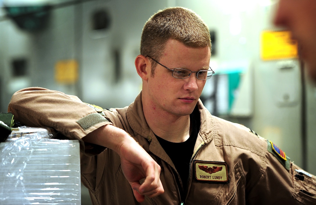 U.S. Air Force Capt. Joshua Flye, a Globemaster III pilot assigned to the 816th Expeditionary Airlift Squadron, listens in on crew discussions during cargo up-load Dec. 8, 2010, for an air drop in support of Operation Enduring Freedom.