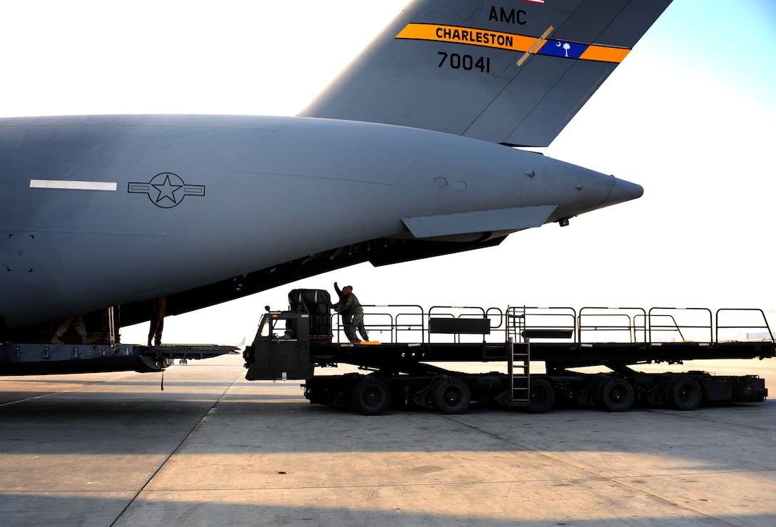 U.S. Army riggers with the 11th Quarter Master Battalion, Fort Bragg, N.C., push bundles of fuel aboard a U.S. Air Force Globemaster III aircraft, which is assigned to the 816th Expeditionary Airlift Squadron, Dec. 8, 2010. The aircraft is gearing up for an air drop mission in support of Operation Enduring Freedom. 