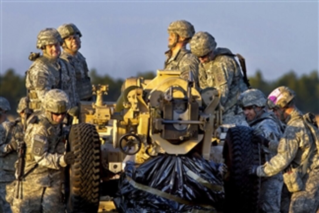 U.S. Army paratroopers remove an M119A2 105mm howitzer from its air-drop packing during a training exercise at Fort Bragg, N.C., on Dec. 3, 2010.  The paratroopers are assigned to the 82nd Airborne Division's 3rd Battalion, 319th Field Artillery Regiment, 1st Brigade Combat Team.  The paratroopers’ goal is to fire the cannon within 20 minutes of the first jumper exiting the aircraft.  