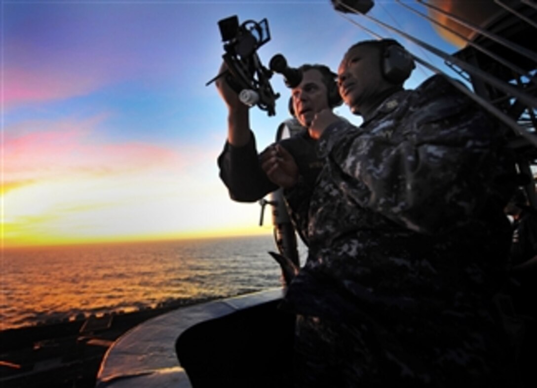 Senior Chief Petty Officer Jonathan Myers teaches Command Master Chief April Beldo how to use a marine sextant during a demonstration of celestial navigation aboard the aircraft carrier USS Carl Vinson (CVN 70) underway in the Pacific Ocean on Dec. 7, 2010.  The Carl Vinson is on a three-week composite training unit exercise to be followed by a deployment to the western Pacific Ocean.  