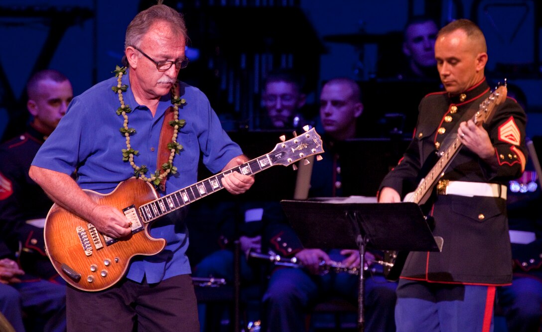 Chris Vandercook, a guitarist and singer, and Staff Sgt. Charles Harbison, a bass guitarist with the U.S. Marine Corps Forces, Pacific, Band, jam Dec. 10 during the third annual Na Mele o na Keiki (Music for the Children) Holiday Concert at the Neal S. Blaisdell Concert Hall here. In addition to spreading holiday cheer and showing support for the community, members of the Marine Corps Reserve’s Toys for Tots Program were on hand to accept donations for children in need living in Hawaii.