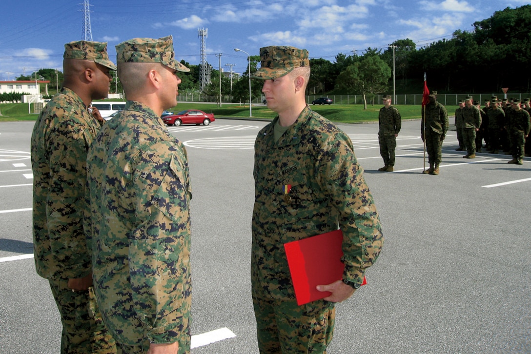 1st Lt. Jeremiah J. Davis, right, is awarded the Navy and Marine Corps Medal for heroism during an awards ceremony Dec. 10, at Camp Hansen by Lt. Col. Ricardo Miagany, middle, commanding officer of 3rd Battalion, 12th Marine Regiment, 3rd Marine Division, III Marine Expeditionary Force and Sgt. Maj. Everett L. Gilliam, 3rd Bn., sergeant major.