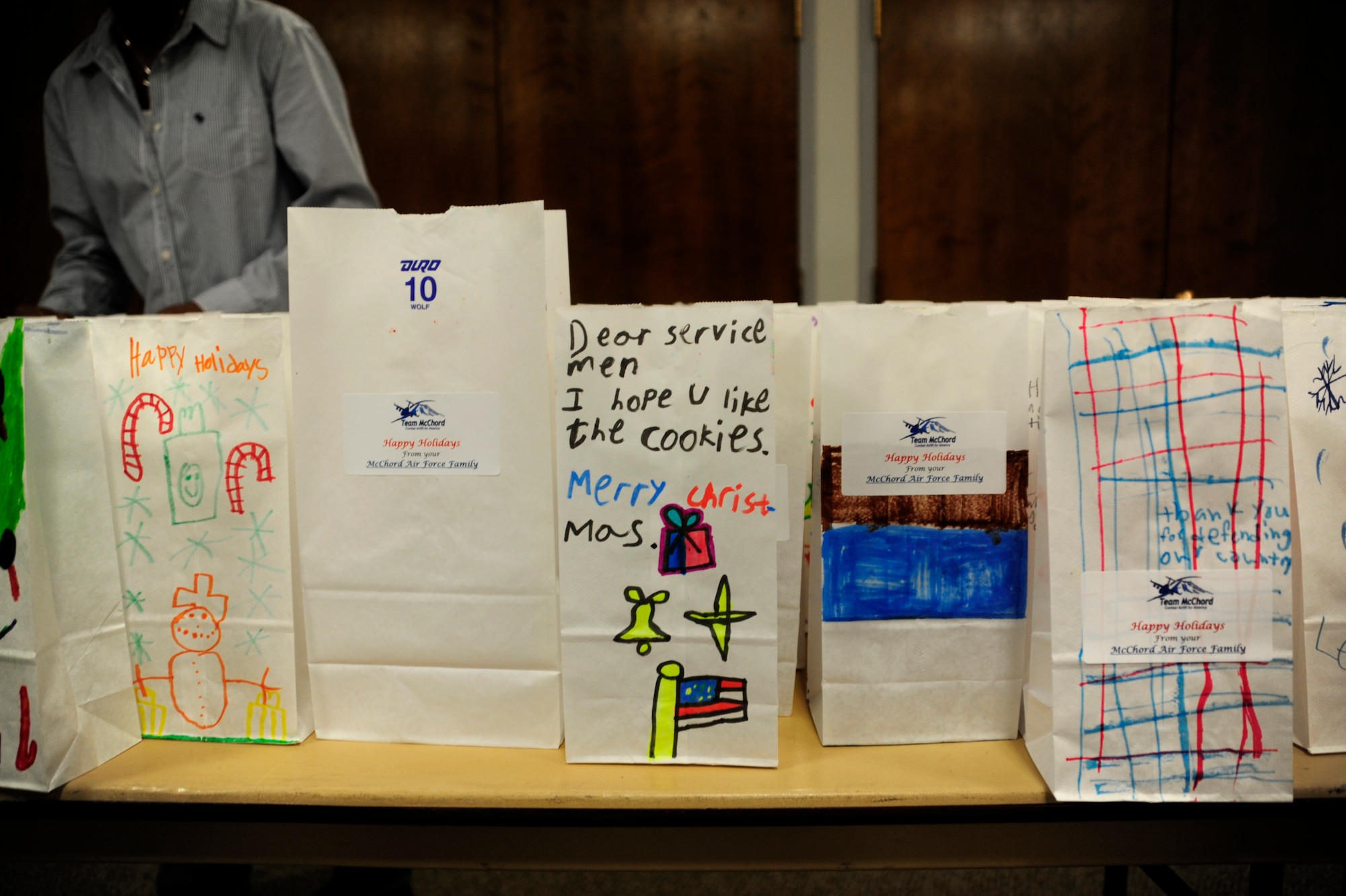 Cookie-filled and crayon-decorated bags are lined up Dec. 10 during the annual McChord cookie drop, hosted by the Chapel Support Center at McChord Field, Joint Base Lewis-McChord, Wash. The bags, decorated by children from Carter Lake Elementary School and McChord Child Development Center, will be distributed by squadron first sergeants to Airmen living in the dorms. (U.S. Air Force photo/Adamarie Lewis-Page)