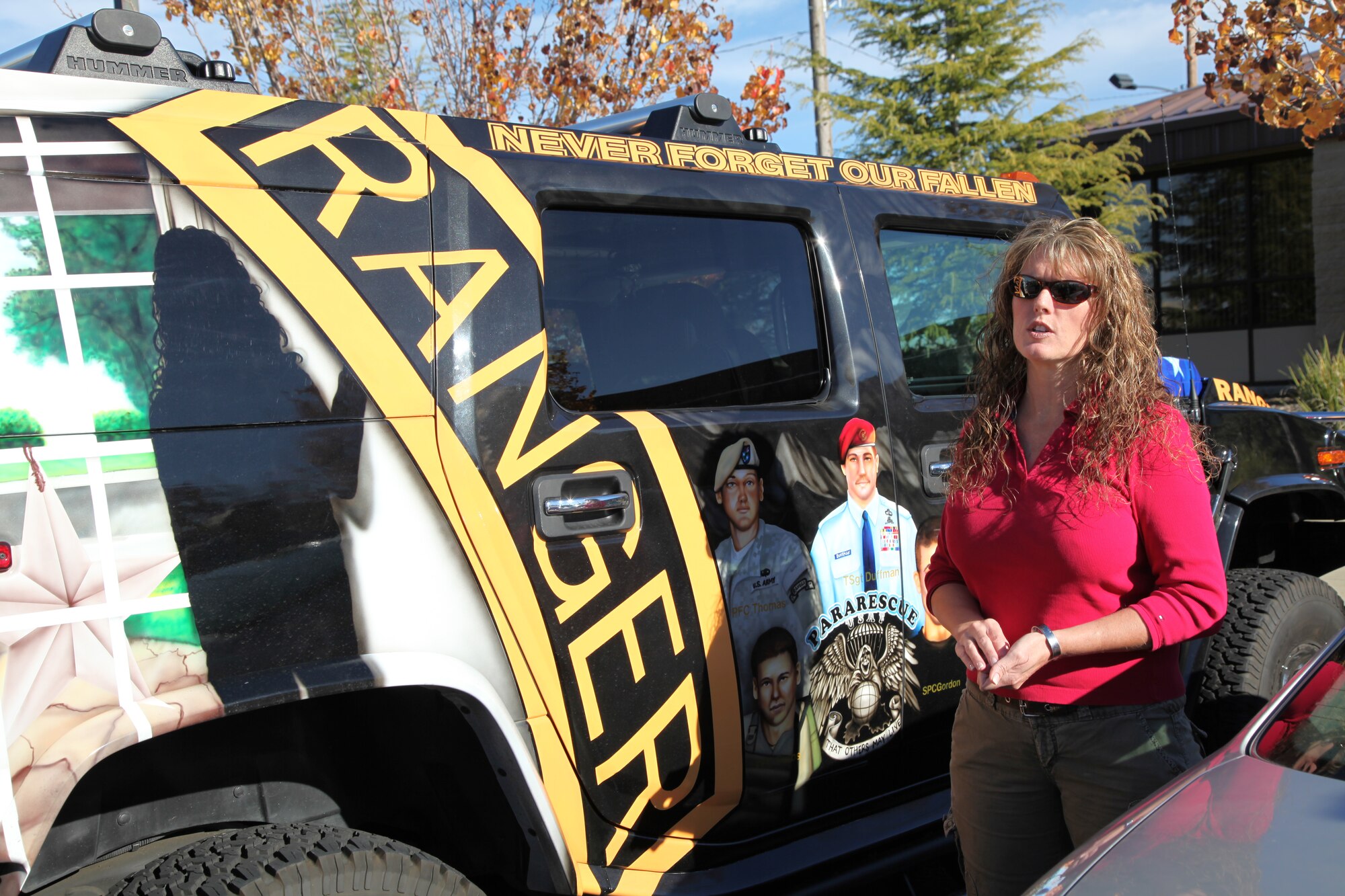 Never Forget Our Fallen founder, Deborah Getz, explains the paintings covering her hummer to 940th Wing members gathered in the parking lot outside of wing headquarters at Beale Air Force Base, Calif., Dec. 7, 2010.  Getz' son, Army Ranger Kristofer Thomas, was killed in Afghanistan in 2007.  Getz was at the 940th Wing to pick up toys donated by Reservists for the wing's annual toy drive. The toys will be distributed by Getz' organization to children of area military families. (U.S. Air Force photo/Tech. Sgt. Kenneth McCann)    