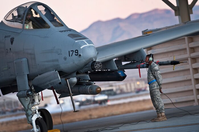 NELLIS AIR FORCE BASE, Nev. -- Senior Airman Edwin Watkins, a crew chief with the 23rd Aircraft Maintenance Squadron communicates with Lt. Col. Jim Clark, 74th Fighter Squadron, commander while conducting pre-flight checks on an A-10 Thunderbolt II before a training mission during the Green Flag West 11-2 exercise at Nellis Dec. 10. Airman Watkins and Lt. Col. Clark are from Moody Air Force Base, Ga., and are deployed to Nellis in support of Green Flag-West. Green Flag-West provides a realistic air-land integration training environment for forces preparing to support worldwide combat operations. (U.S. Air Force photo by Tech. Sgt. Michael R. Holzworth)
