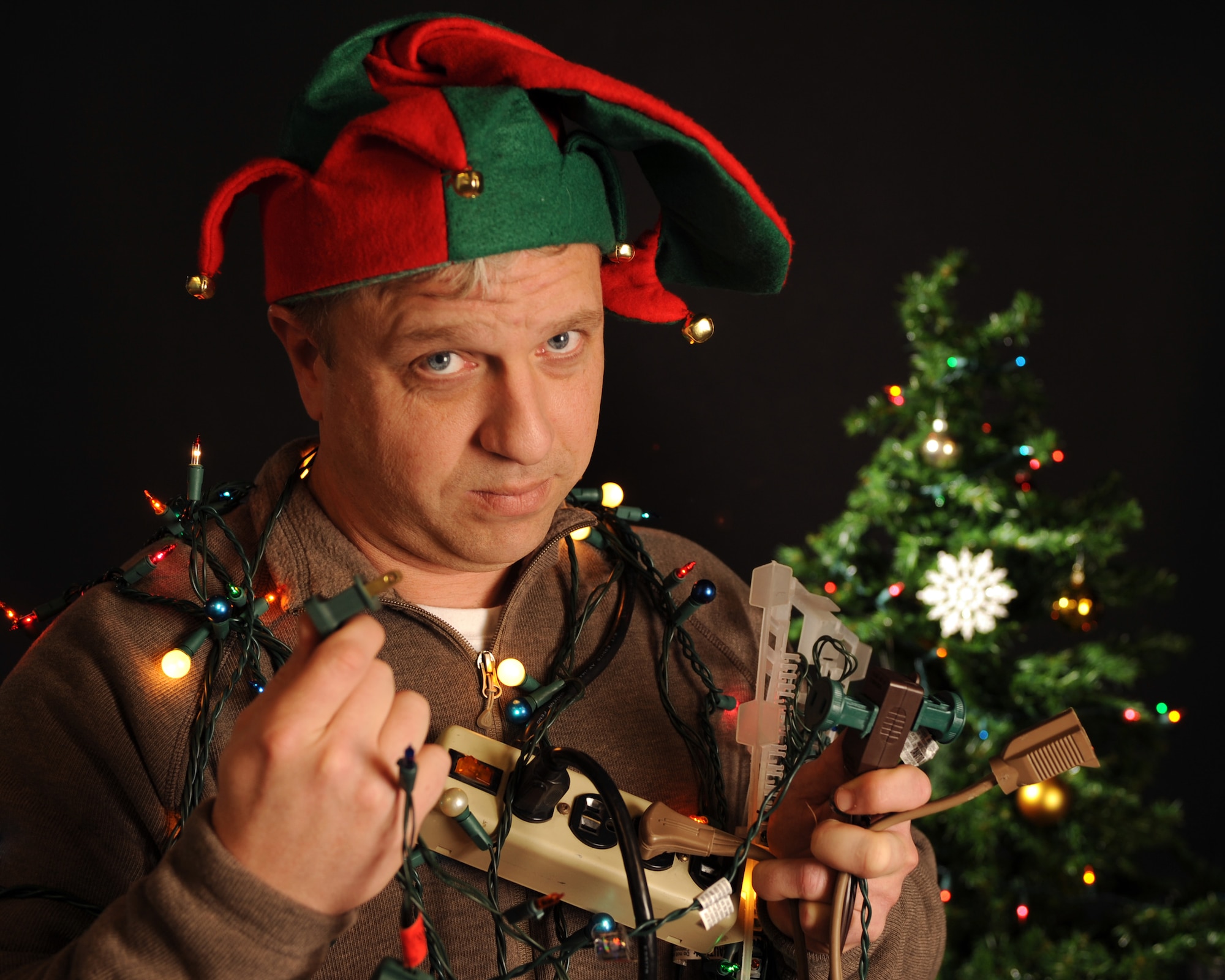ELLSWORTH AIR FORCE BASE, S.D. -- Ian Smith, 28th Bomb Wing Information Protection personnel security assistant, demonstrates the improper use of electrical devices and holiday lights.  Electrical safety and fire prevention are essential during the holiday season. (U.S. Air Force photo/Staff Sgt. Marc I. Lane)