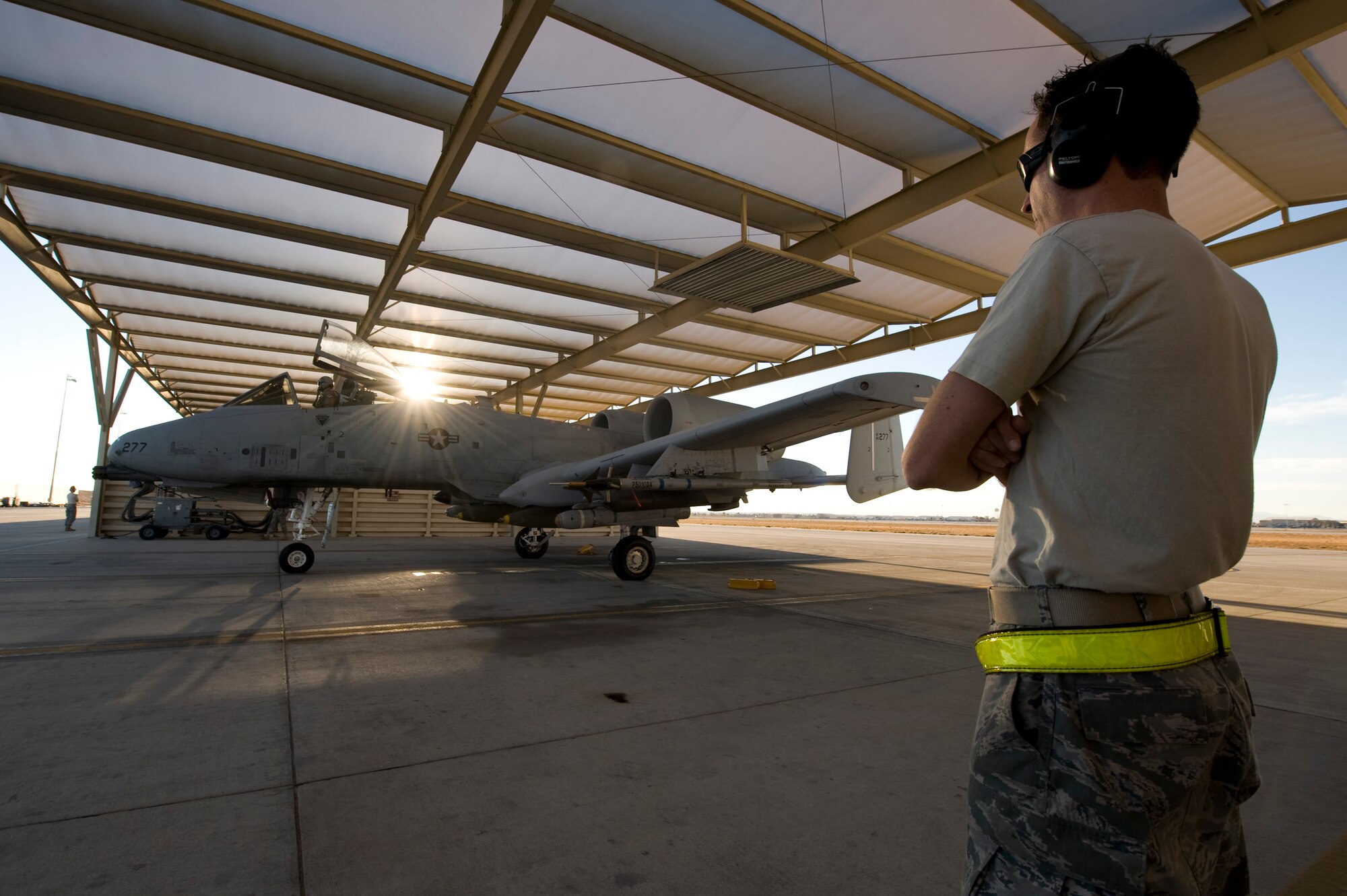 NELLIS AIR FORCE BASE, Nev. -- Senior Airman Wade McFarland, a crew chief with the 23rd Aircraft Maintenance Squadron from Moody Air Force Base, Ga., looks on as 74th Fighter Squadron A-10 Thunderbolt II prepares to depart fro a training mission during Green Flag West 11-2 exercise at Nellis Dec. 6. Green Flag-West provides a realistic air-land integration training environment for forces preparing to support worldwide combat operations. (U.S. Air Force photo by Senior Airman Brett Clashman)