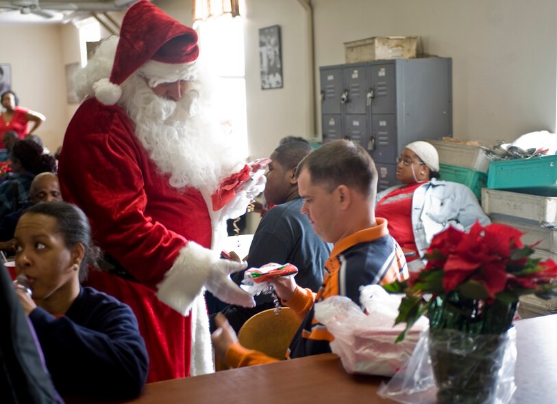 Santa Claus hands out gifts to Hap House clients during the Hap House holiday party on Barksdale Air Force Base, La., Dec. 9. Established in 1976, the Hap House is a non-profit organization on Barksdale providing more than 80 mentally and physically disabled adults the opportunity to earn a pay check. (U.S. Air Force Photo by Senior Airman Chad Warren) (RELEASED)