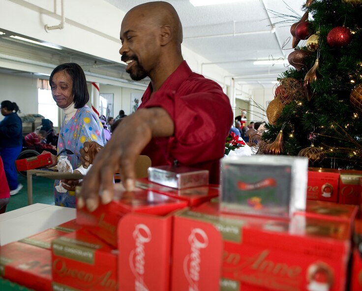 Hap House program director James Williams hands out prizes during the Hap House holiday party on Barksdale Air Force Base, La., Dec. 9. Established in 1976, the Hap House is a non-profit organization on Barksdale providing more than 80 mentally and physically disabled adults the opportunity to earn a pay check. The Barksdale Officers? Spouses? Club held a silent auction which raised more than $2,100 to host the holiday party. (U.S. Air Force Photo by Senior Airman Chad Warren) (RELEASED)