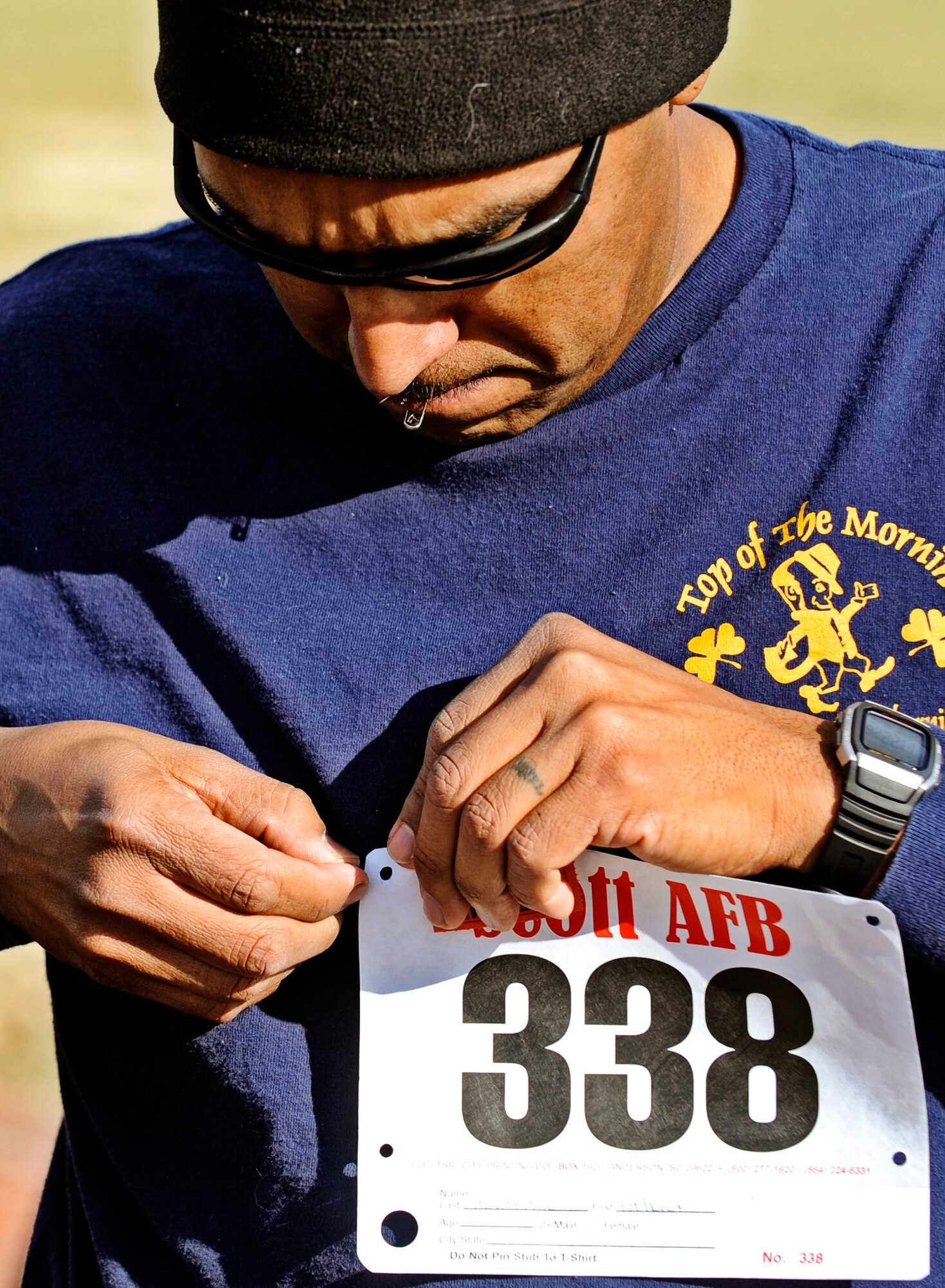 Tech Sgt. Patrick Alvarado, 932nd Maintenance Squadron, pins on his race bib on prior to the start of the Holiday Frigid 5K Dec 10. More than 200 people participated in the event hosted by the 375th Force Support which was open to all members of Team Scott. (U.S. Air Force photo/ Staff Sgt. Ryan Crane)