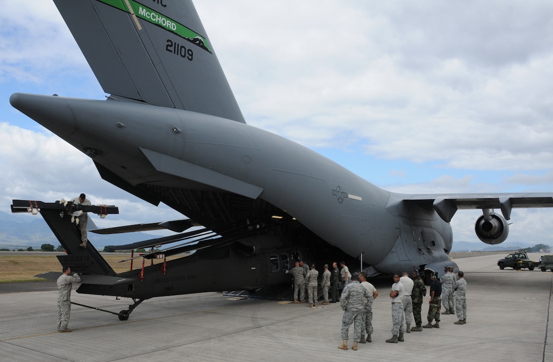 SOTO CANO AIR BASE, Honduras --  Members of Joint Task Force-Bravo watch as a Black Hawk helicopter is unloaded from a C-17 Globemaster III here Dec. 9. The C-17, which is from McChord AFB, Wash., delivered the helicopter after it received repairs in the U.S. (U.S. Air Force photo/Tech. Sgt. Benjamin Rojek)