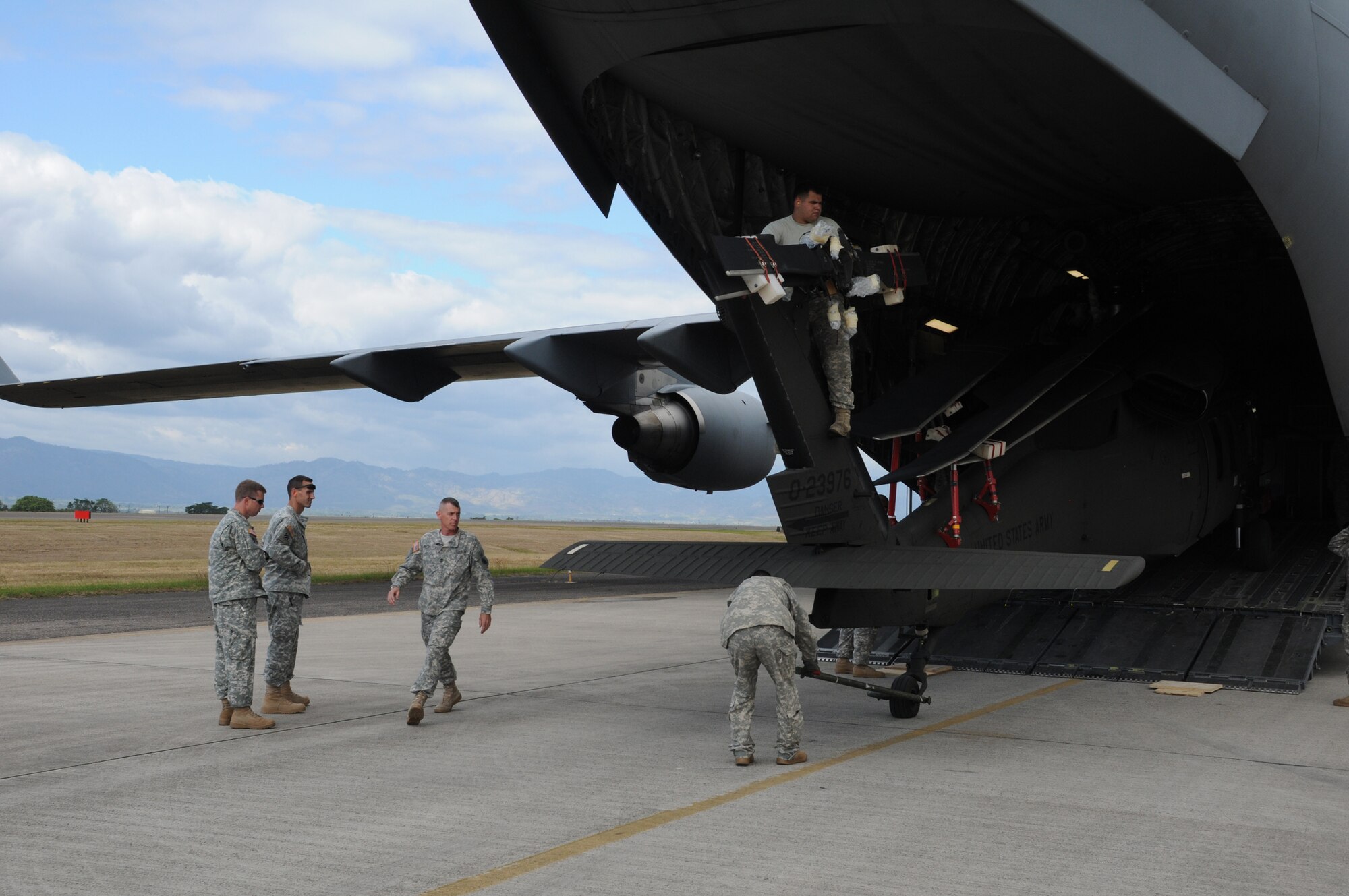 SOTO CANO AIR BASE, Honduras --  Checking to make sure they're clearing the ramp, members of the 1-228th Aviation Regiment pull a Black Hawk helicopter from inside a C-17 Globemaster III here Dec. 9. The helicopter, which was delivered by the C-17 out of McChord AFB, Wash., was returned to Soto Cano after receiving repairs in the U.S. (U.S. Air Force photo/Tech. Sgt. Benjamin Rojek)