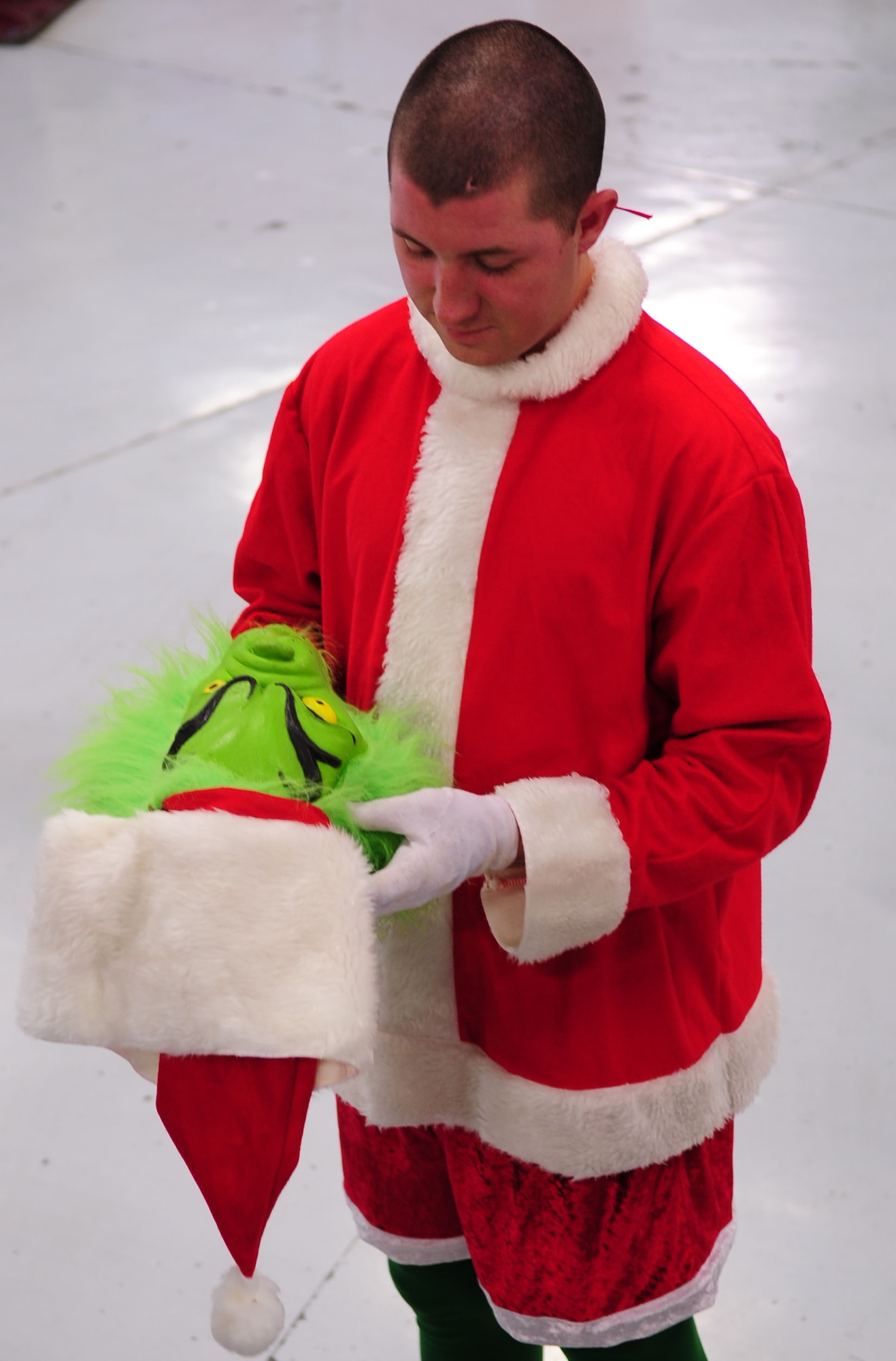 MOODY AIR FORCE BASE, Ga. -- Airman 1st Class Jacob Couch, 23rd Logistics Readiness Squadron vehicle maintainer, tries on the Grinch costume he will be wear during the Annual Base Tree Lighting and Holiday Parade Dec. 9. Along with the Grinch, an elf and a reindeer will accompany the children of the squadron’s members during the parade. (U.S. Air Force photo/Senior Airman Stephanie Mancha)(RELEASED)