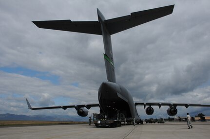 SOTO CANO AIR BASE, Honduras --  After lowering the ramp, crewmembers of the C-17 Globemaster III and members of the 612th Air Base Squadron unload cargo before preparing to unload a Black Hawk helicopter here Dec. 9. (U.S. Air Force photo/Tech. Sgt. Benjamin Rojek)