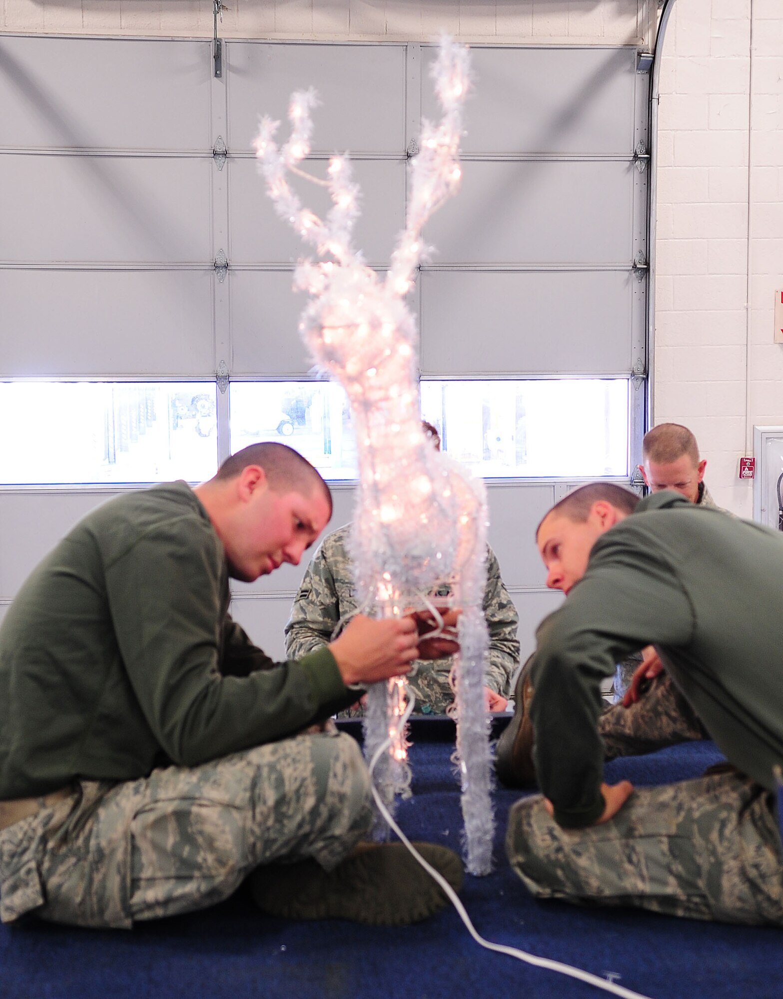 MOODY AIR FORCE BASE, Ga. -- Airman 1st Class Jacob Couch (left) and Airman 1st Class Stephen Bost, 23rd Logistics Readiness Squadron vehicle maintainers, assembles an animated deer sculpture for the squadron float Dec. 9. Throughout 15 years, the 23rd LRS has collected various decorations for the holiday float. (U.S. Air Force photo/Senior Airman Stephanie Mancha)(RELEASED)
