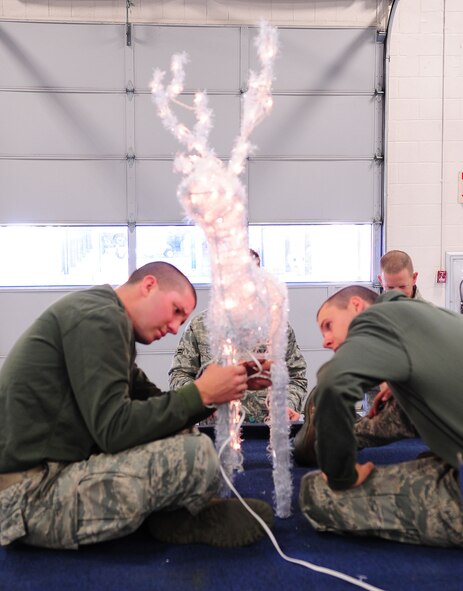 MOODY AIR FORCE BASE, Ga. -- Airman 1st Class Jacob Couch (left) and Airman 1st Class Stephen Bost, 23rd Logistics Readiness Squadron vehicle maintainers, assembles an animated deer sculpture for the squadron float Dec. 9. Throughout 15 years, the 23rd LRS has collected various decorations for the holiday float. (U.S. Air Force photo/Senior Airman Stephanie Mancha)(RELEASED)