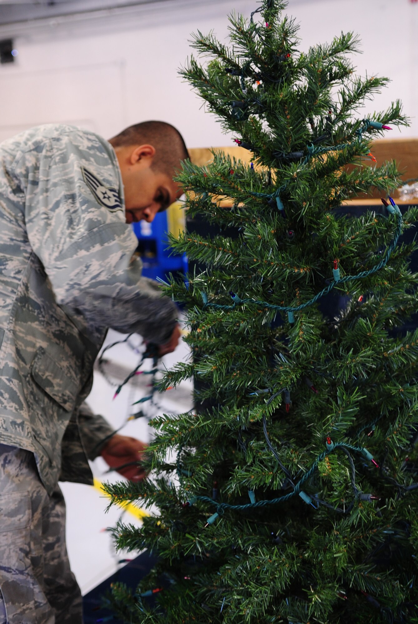MOODY AIR FORCE BASE, Ga. -- Staff Sgt. Albaro Alanis, 23rd Logistics Readiness Squadron vehicle maintainer, decorates a Christmas tree with lights Dec. 9. The tree is one of the decorations that will appear on the squadron’s float during the Annual Base Tree Lighting and Holiday Parade. (U.S. Air Force photo/Senior Airman Stephanie Mancha)(RELEASED)