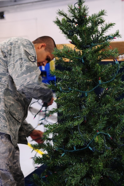 MOODY AIR FORCE BASE, Ga. -- Staff Sgt. Albaro Alanis, 23rd Logistics Readiness Squadron vehicle maintainer, decorates a Christmas tree with lights Dec. 9. The tree is one of the decorations that will appear on the squadron’s float during the Annual Base Tree Lighting and Holiday Parade. (U.S. Air Force photo/Senior Airman Stephanie Mancha)(RELEASED)