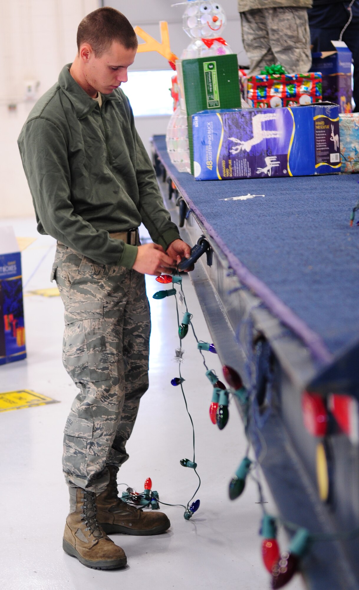 MOODY AIR FORCE BASE, Ga. -- Airman 1st Class Stephen Bost, 23rd Logistics Readiness Squadron vehicle maintainer, attaches lights around the bed of trailer Dec. 9. “We enjoy building holiday floats every year for the children in our Air Force family,” said Dave Stokes, 23rd Logistics Readiness Squadron mechanic. (U.S. Air Force photo/Senior Airman Stephanie Mancha)(RELEASED)