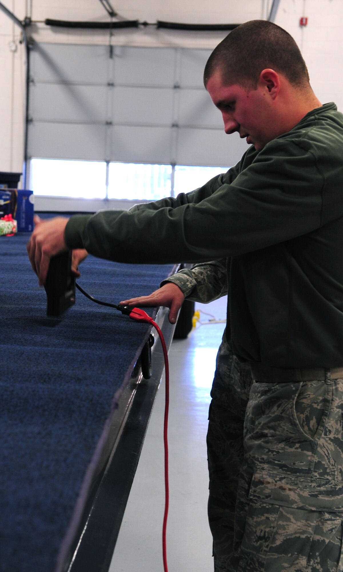 MOODY AIR FORCE BASE, Ga. -- Airman 1st Class Jacob Couch, 23rd Logistics Readiness Squadron vehicle maintainer, staples a rug onto the bed of a trailer Dec. 9.  Stapling the rug is the first step in building a float for the Annual Base Tree Lighting and Holiday Parade. The rug helps to keep all the decorations in place. (U.S. Air Force photo/Senior Airman Stephanie Mancha)(RELEASED)
