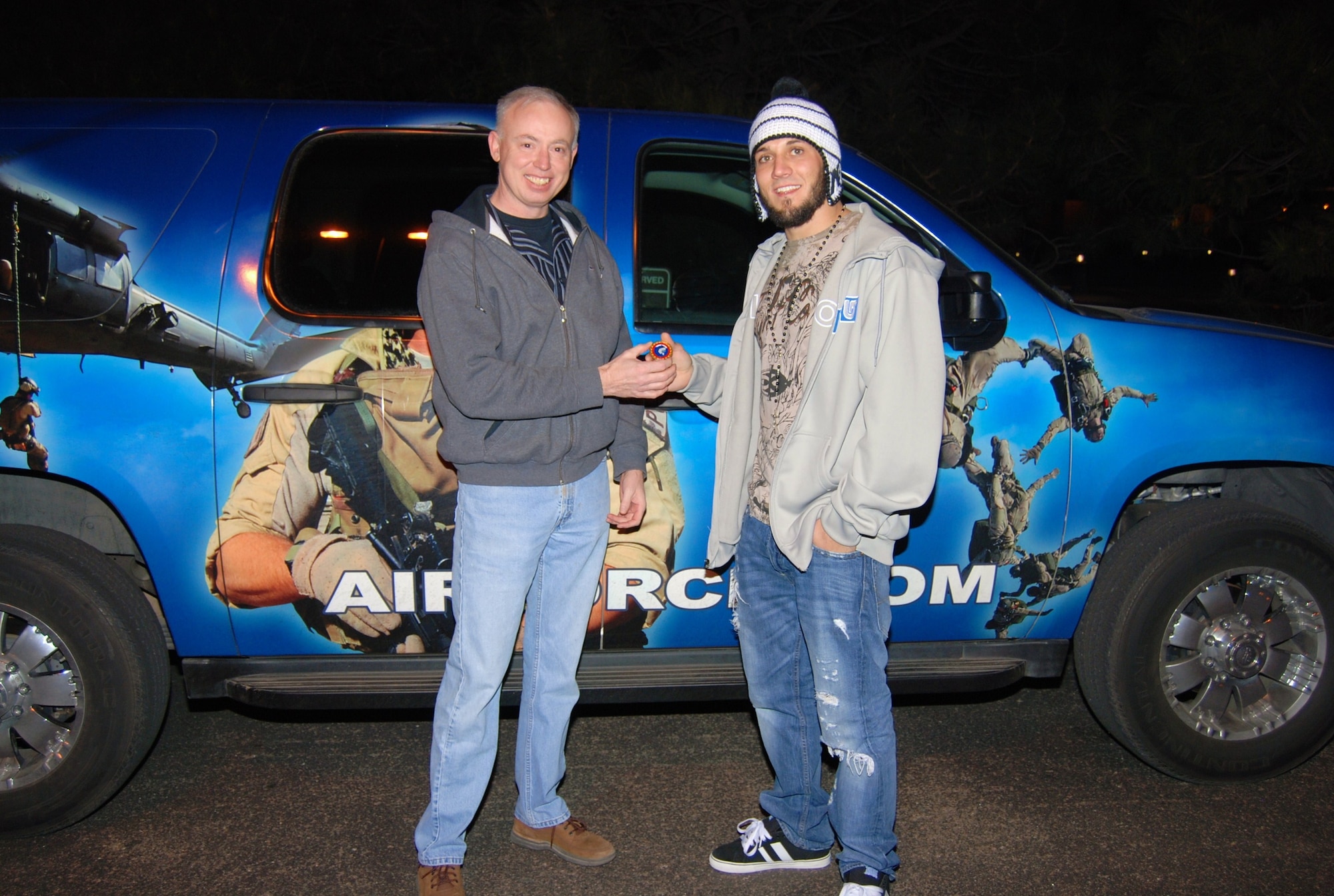 Lt. Col. Larry Norman, 367th Recruiting Squadron commander in Colorado Springs, presents a coin to Cameron Dollar, a mixed martial artist and former UFC fighter outside The Club on Peterson Air Force Base Nov. 20. Mr. Dollar is teaming with the 367 RCS to promote the Air Force Special Forces’ program. (U.S. Air Force photo/Airman 1st Class Jessica Hines) 