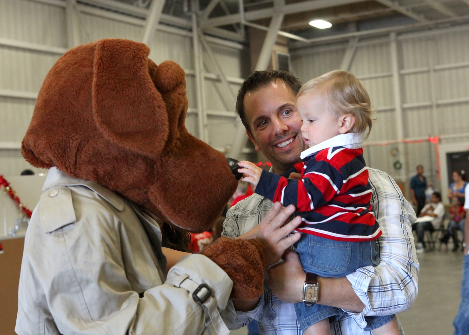 McGruff the Crime Dog greets James Shappell, a civilian employee with the 344th Training Squadron, and his son, Josh, during the Lackland Children's Holiday Party. The base-wide event was held Dec. 4 at the 344th TRS. (U.S. Air Force photo/Robbin Cresswell)