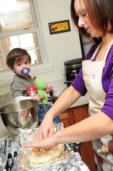 Jessica Kelly, wife of Staff Sgt. Patrick Kelly, 2nd Civil Engineer Squadron plumber, makes cookies with the help of their son Jody, 1, at her home Dec. 6. Mrs. Kelly provided baked goods for the dorm cookie drive to help boost morale of dorm residents during the holiday season. (U.S. Air Force photo/Senior Airman Joanna M. Kresge)