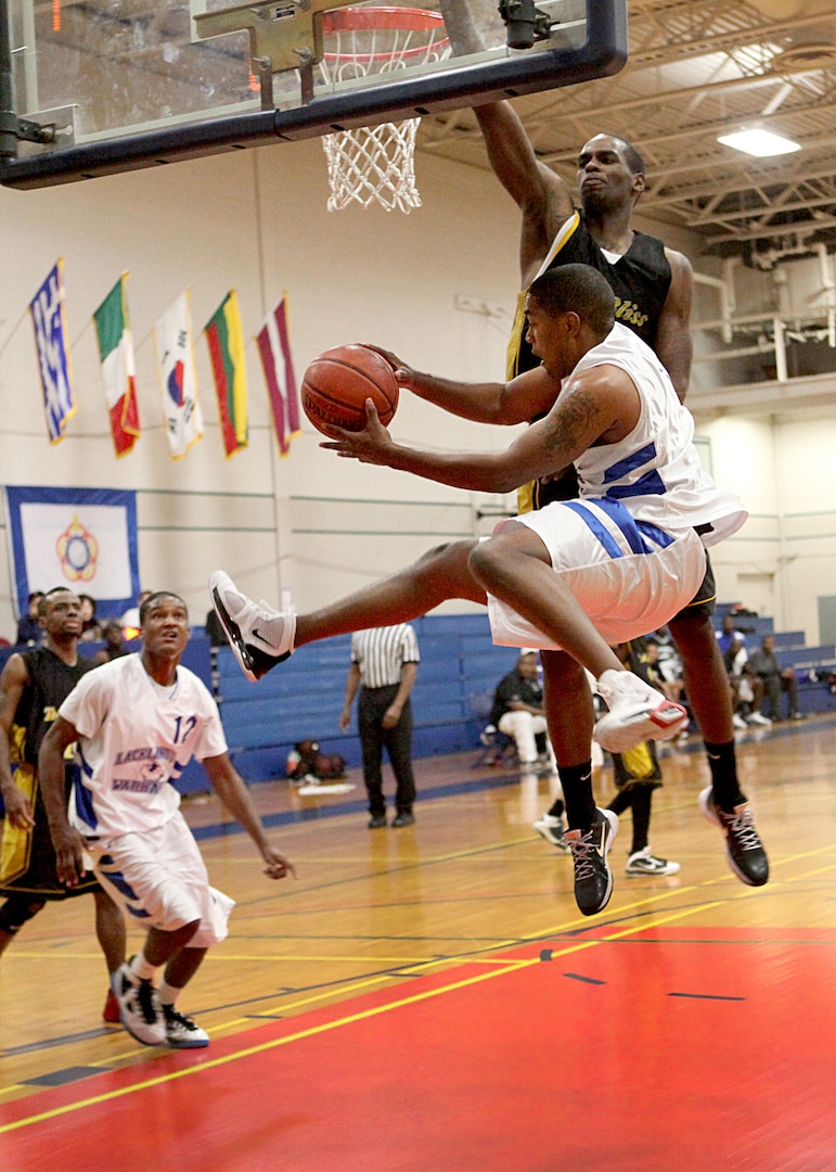 Lackland's Damion Turner looks to pass to Chris Grimmsley cutting toward the basket during the tournament championship against Fort Bliss Dec. 5. (U.S. Air Force photo/Robbin Cresswell) 