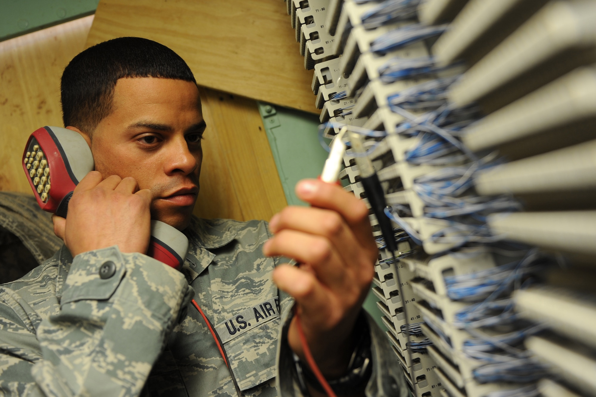 Staff Sgt. Edwin Dones troubleshoots a telephone line Dec. 10, 2010, at Kandahar Airfield, Afghanistan. Airmen of the 451st Expeditionary Communications Squadron are responsible for managing, maintaining, and operating more than $30 million worth of equipment and keeping 2,000-3,000 customers happy. Sergeant Dones, from San Juan, Puerto Rico, is a cable and antenna systems journeyman assigned to the 451st ECS. (U.S. Air Force photo by Tech. Sgt. Chad Chisholm/Released)