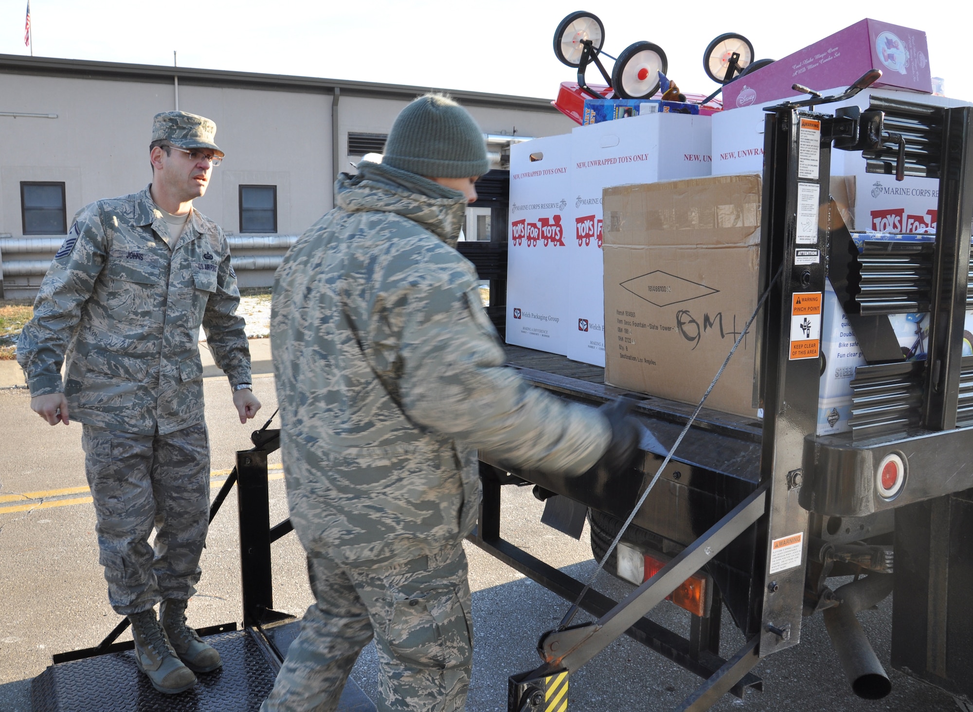 WRIGHT-PATTERSON AIR FORCE BASE, Ohio – Staff Sgt. Eddie Mulkey, 445th Aeromedical Evacuation Squadron, finishes loading the last box of toys onto the back of a truck as Master Sgt. Anthony Johns, 445th Maintenance Operations Flight first sergeant, looks on for the Toys for Tots program Dec. 9. The wing collected 787 toys weighing more than 4,460 pounds.  (U.S. Air Force photo/Stacy Vaughn)