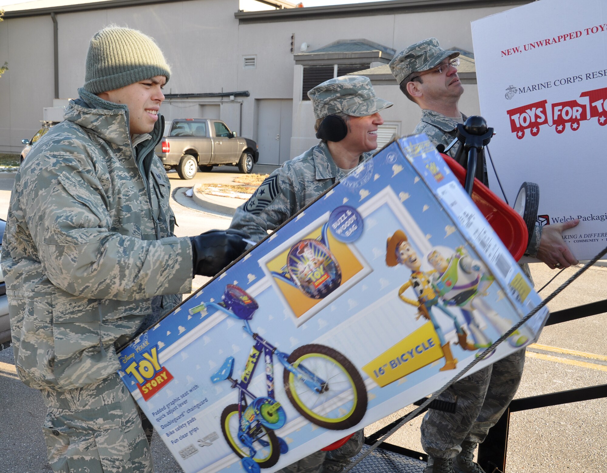 WRIGHT-PATTERSON AIR FORCE BASE, Ohio – Staff Sgt. Eddie Mulkey, 445th Aeromedical Evacuation Squadron, loads a bicycle onto the back of a truck as Chief Master Sgt. Peri Rogowski, 445th Airlift Wing command chief, and Master Sgt. Anthony Johns, 445th Maintenance Operations Flight first sergeant, load other toys onto a truck for the Toys for Tots program Dec. 9. The wing collected 787 toys weighing more than 4,460 pounds.  (U.S. Air Force photo/Stacy Vaughn)