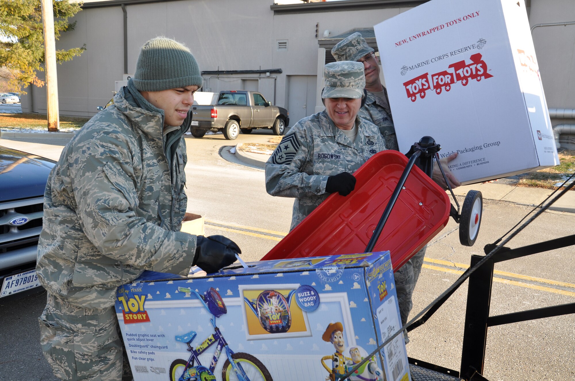 WRIGHT-PATTERSON AIR FORCE BASE, Ohio – Staff Sgt. Eddie Mulkey, 445th Aeromedical Evacuation Squadron, loads a bicycle onto the back of a truck as Chief Master Sgt. Peri Rogowski, 445th Airlift Wing command chief, and Master Sgt. Anthony Johns, 445th Maintenance Operations Flight first sergeant, load other toys onto a truck for the Toys for Tots program Dec. 9. The wing collected 787 toys weighing more than 4,460 pounds.  (U.S. Air Force photo/Stacy Vaughn)