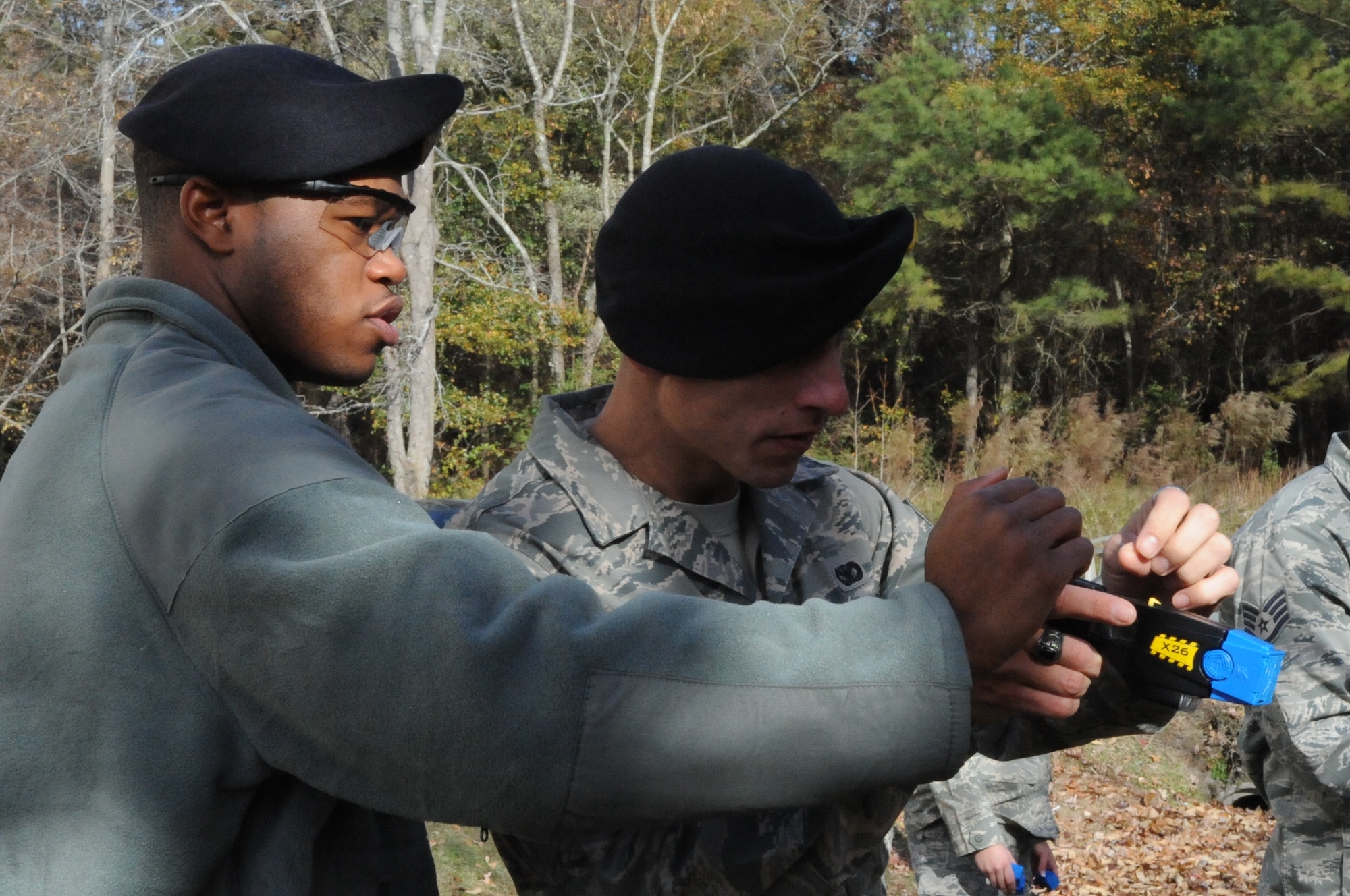 SEYMOUR JOHNSON AIR FORCE BASE, N.C. -- Staff Sgt. Lionel Peake-Marshall instructs a security forces Airman on how to properly turn on the laser sight during taser training here, Dec. 8, 2010. The training is designed to teach Airmen about the 226 model tasers, how the human body reacts when tased, as well as giving them another option of stopping a suspect without using lethal force. Sergeant Peake-Marshall is a 4th Security Forces Squadron trainer from Los Angeles. (U.S. Air Force photo/Staff Sgt. Courtney Richardson)(RELEASED)