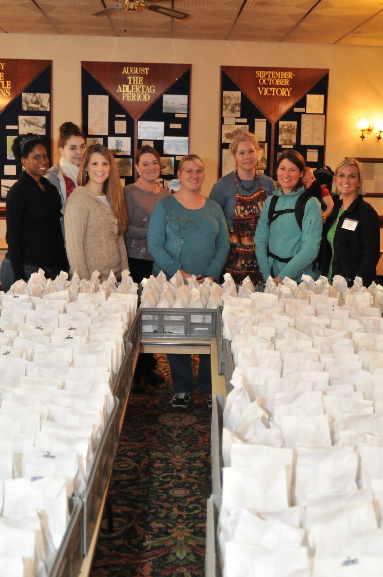 ROYAL AIR FORCE LAKENHEATH, England -- Volunteers stand with just a few of the cookies donated to the Airmen’s Holiday Cookie Drive at the Eagles Landing club Dec. 9. More than 16,000 cookies were donated for single Airmen living in dormitories on base and serving at deployed locations.  (U.S. Air Force photo/Senior Airman David Dobrydney)