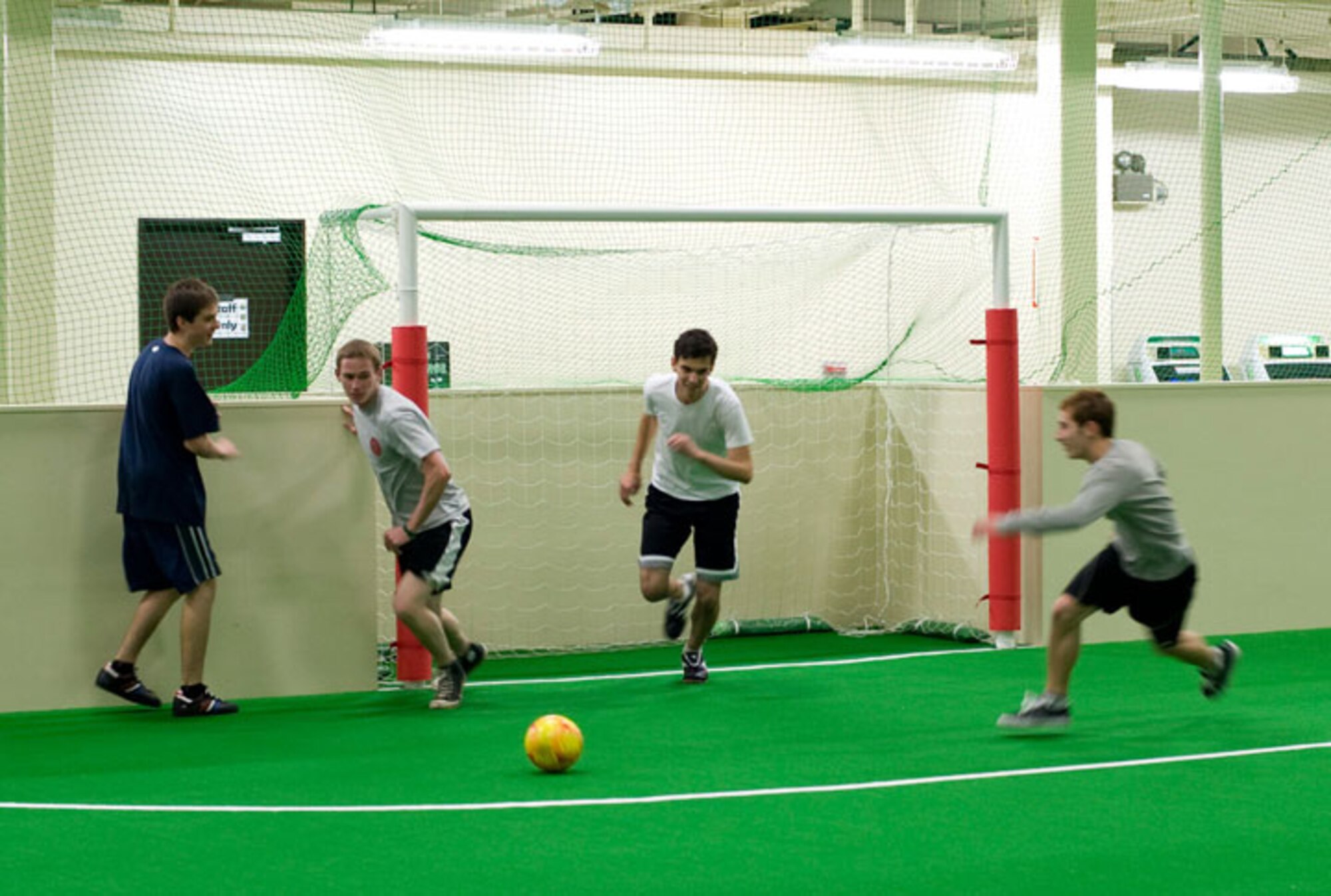 Visitors to the Weasels’ Den at Misawa Air Base, Japan, play soccer in the newly renovated indoor soccer field, Dec. 8, 2010. Soccer field upgrades include a 3-foot surrounding wall with netting extending towards the ceiling, soccer goal posts are now built into the ground, and the new astro-turf has all the lines for a regulation soccer field. (U.S. Air Force photo by Airman James B. Bauer/Released)