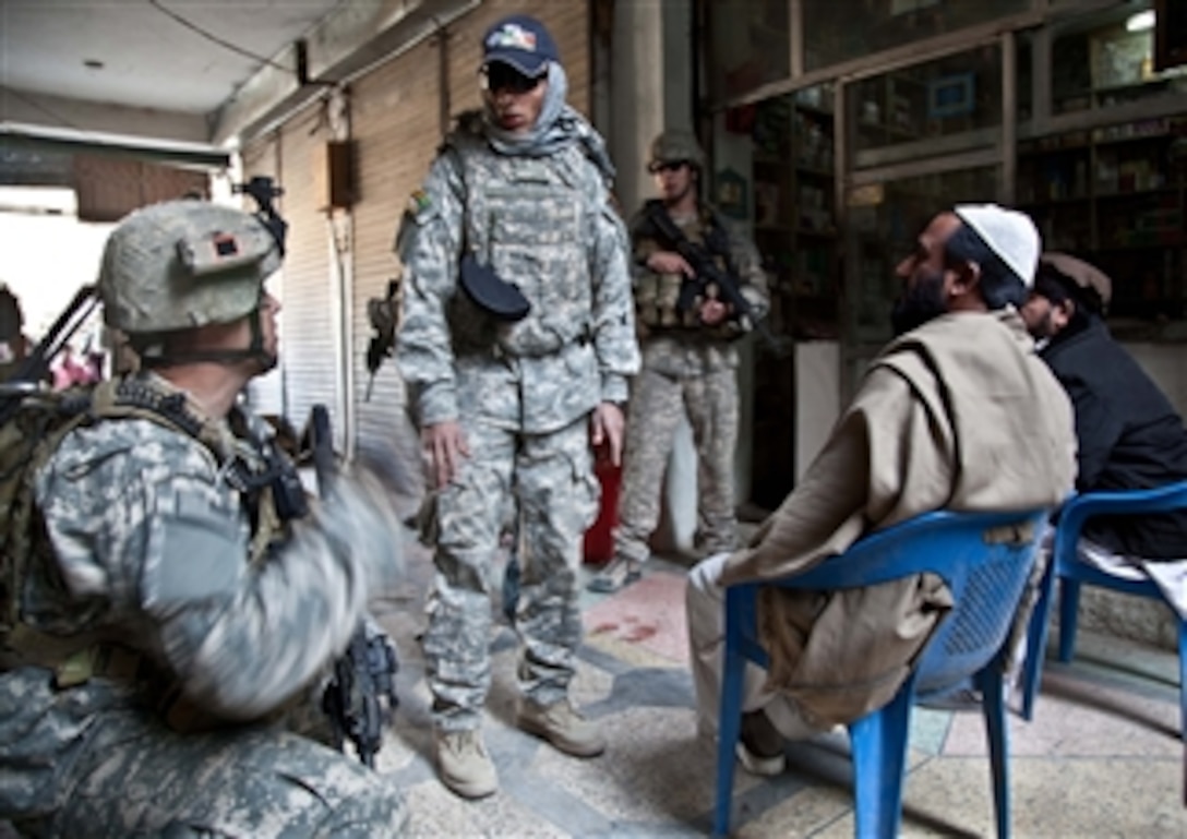 U.S. Army Staff Sgt. Brain Sewick (left), a platoon sergeant with Tactical Psychological Operations Team 1316, asks a series of questions to Afghans during a patrol in Khost City, Khost province, Afghanistan, on Dec. 5, 2010.  The purpose of the patrol was to assess local insurgent activity during daytime hours.  